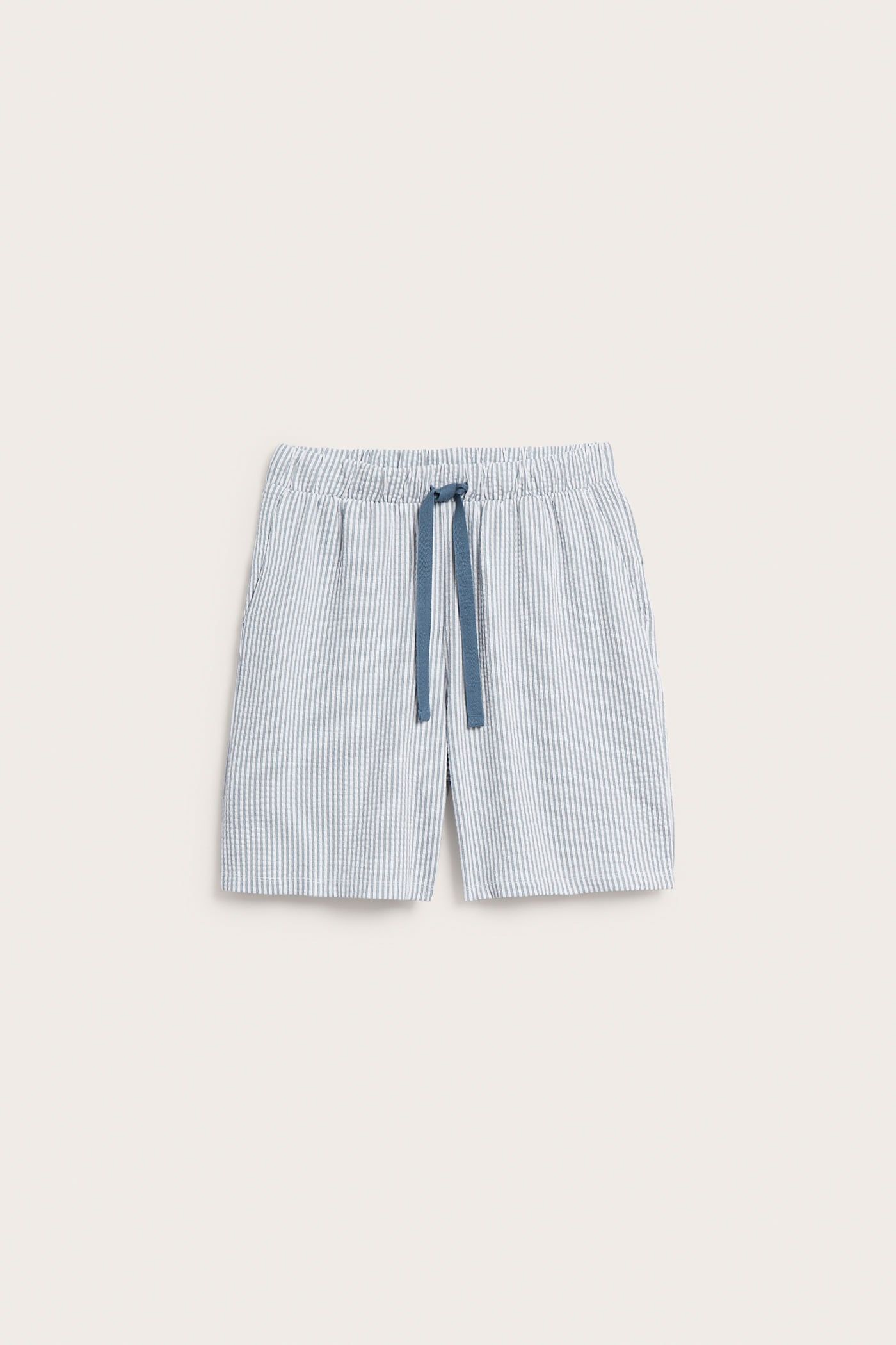 Frontvy av herrpyjamasshorts i ljusblå och vitrandig bäckebölja med mörkblå dragsko.