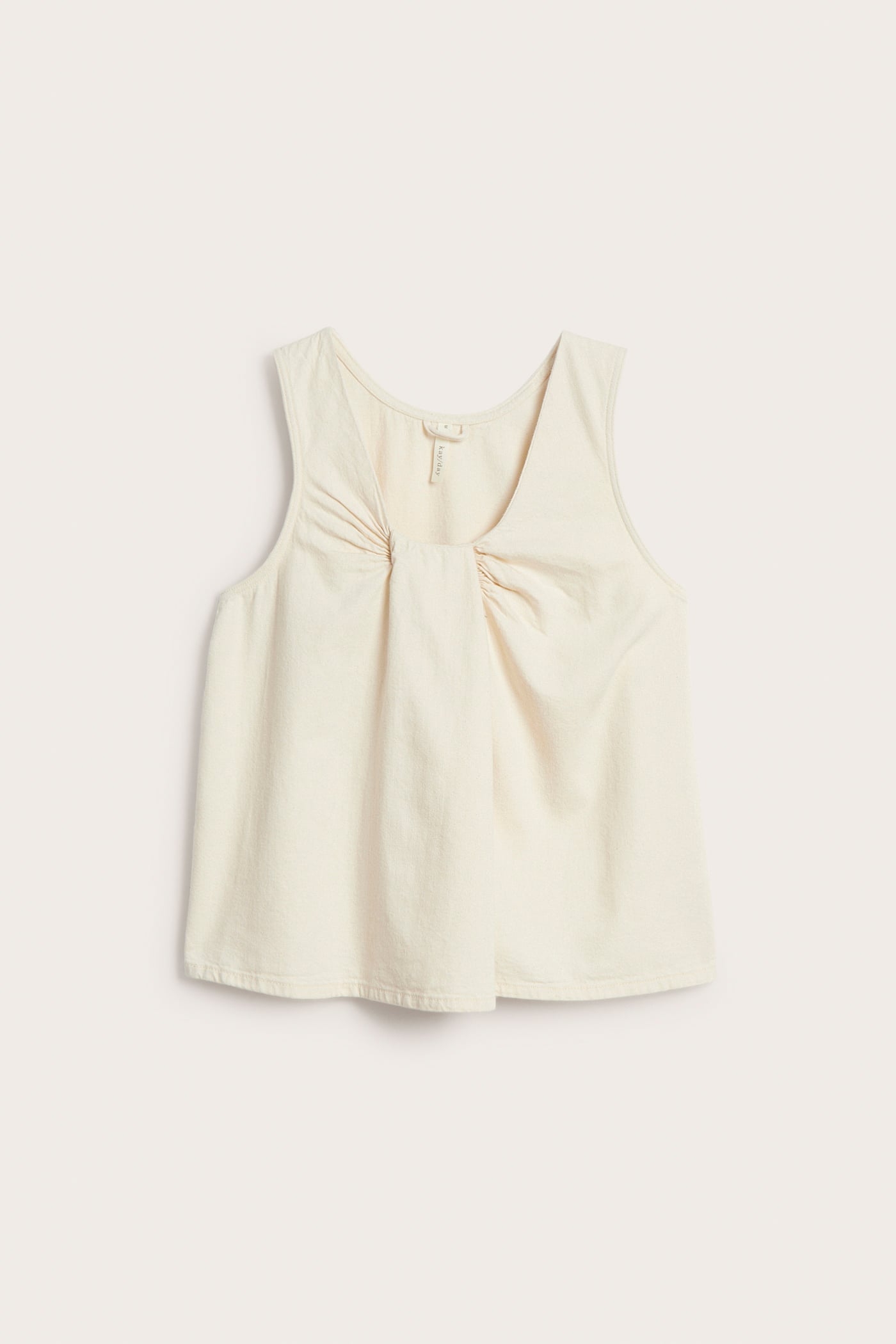 Framifrån, beige ärmlös topp i bomullsdenim med knuten detalj vid ringningen.