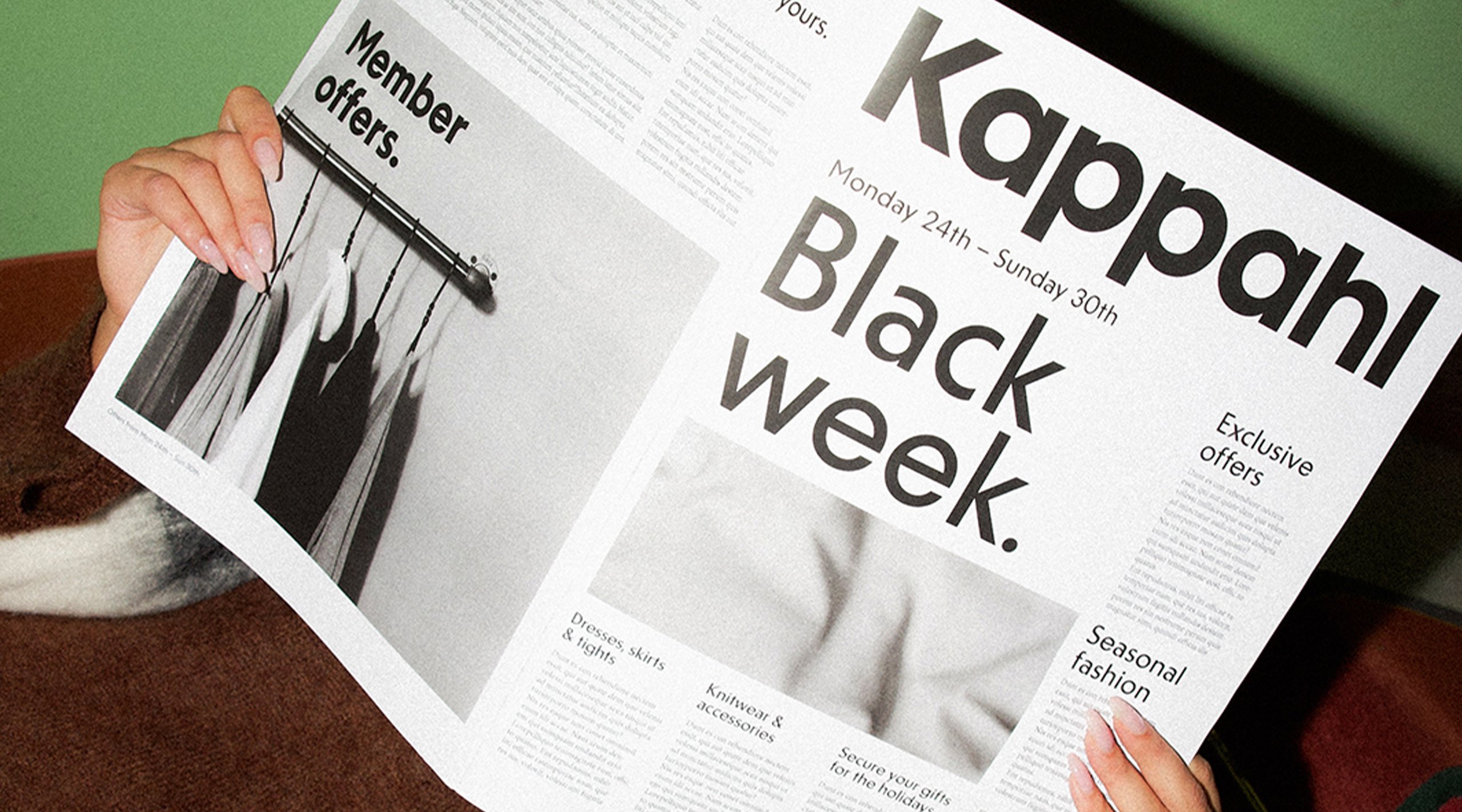 En person som håller upp en tidning med Kappahls Black Week
