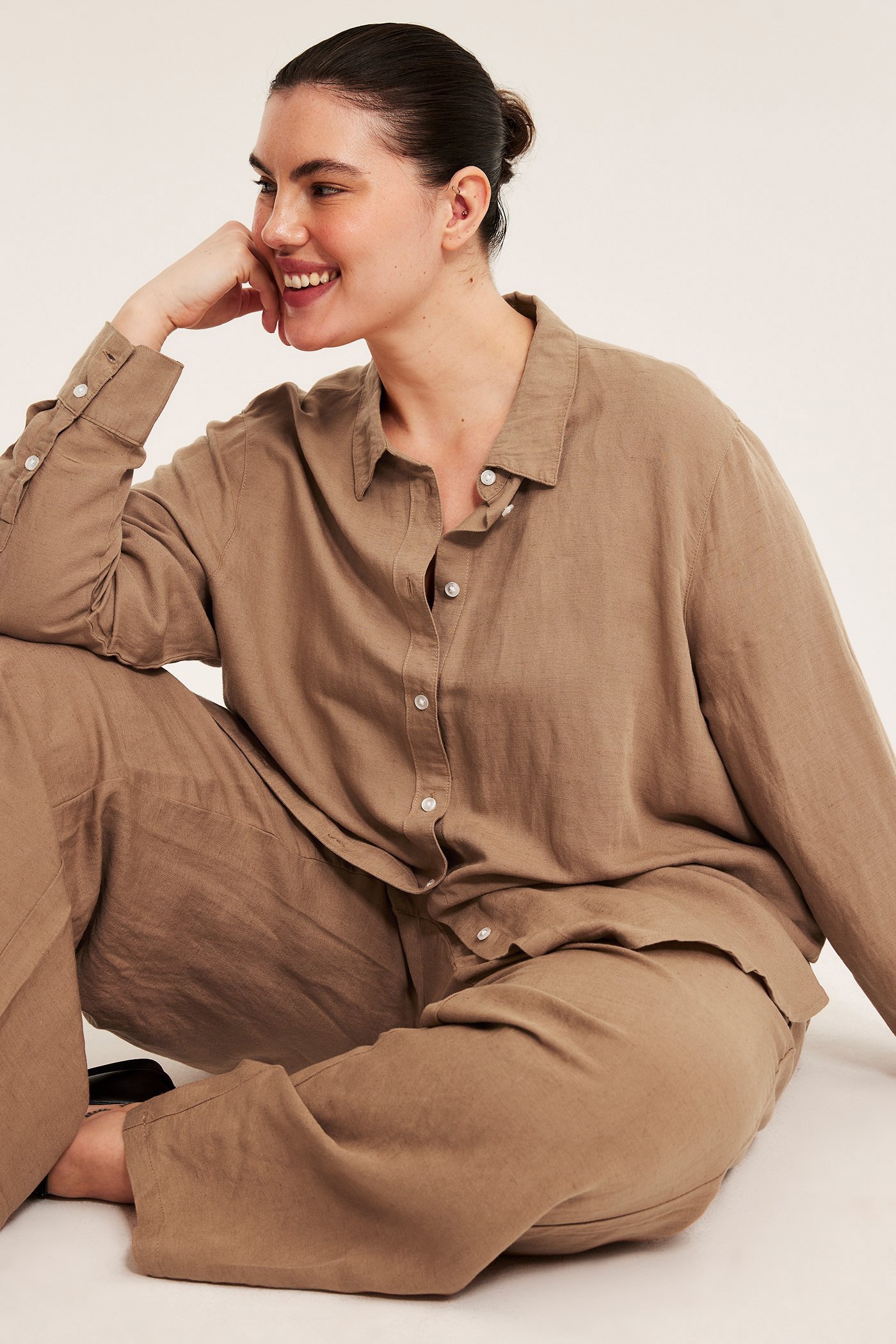 Kobieta plus size w brązowym, pasującym topie na ramiączkach.