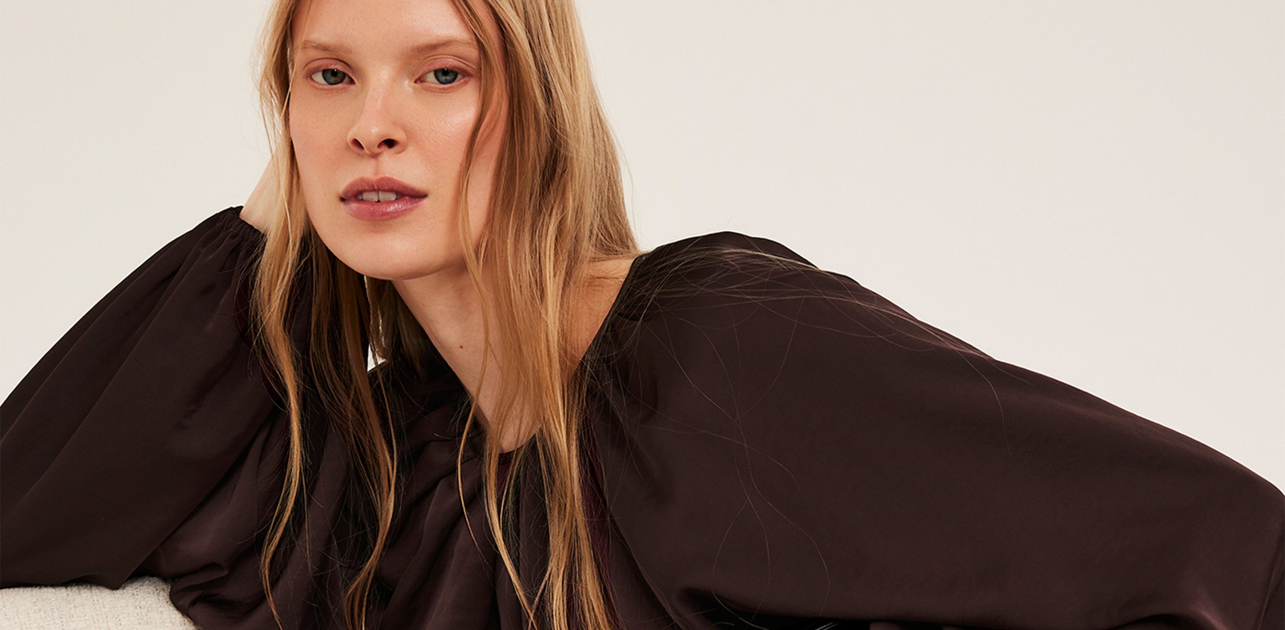 Kvinna i en mörk vinröd satinblus