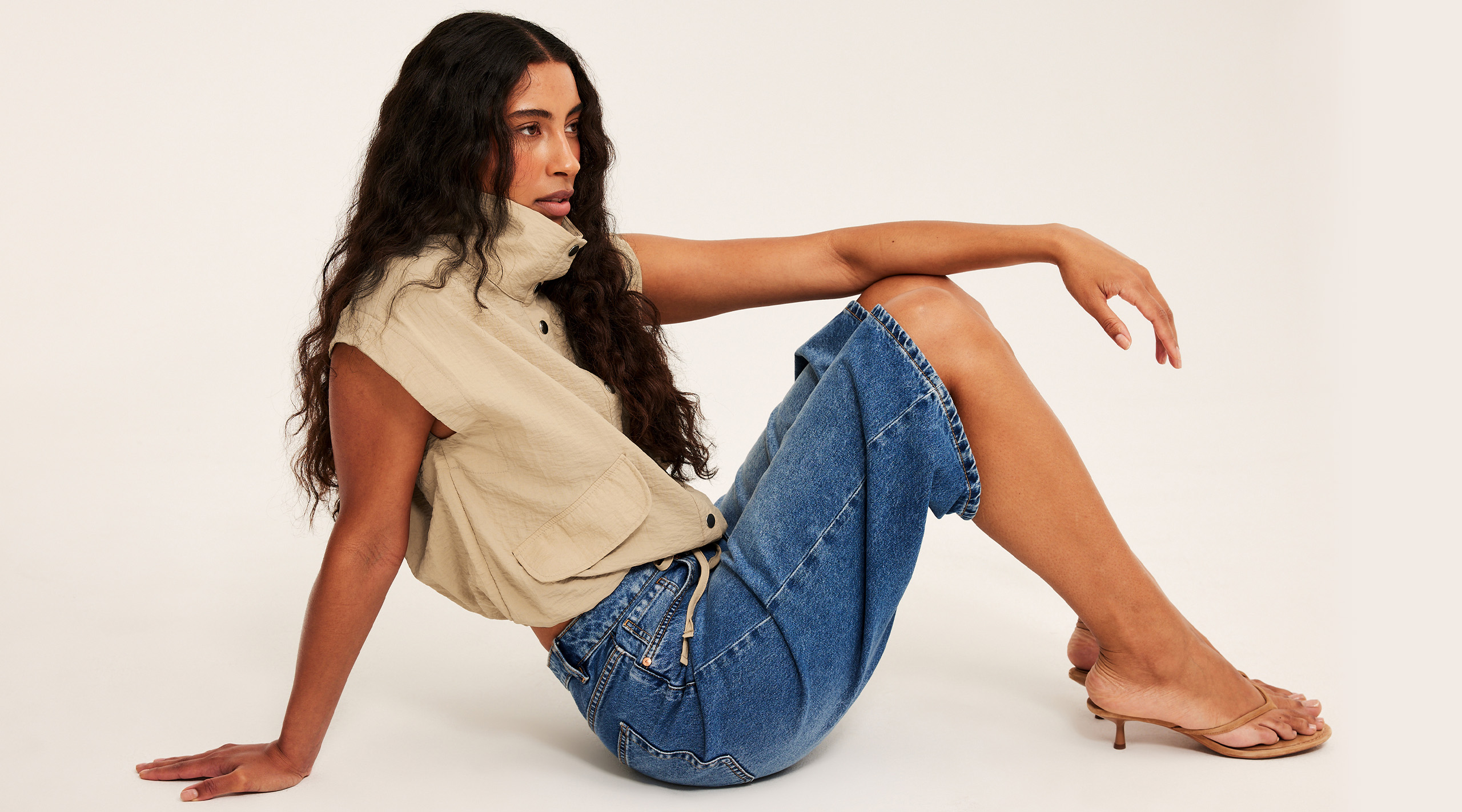 Kvinna i en beige topp med sportig look