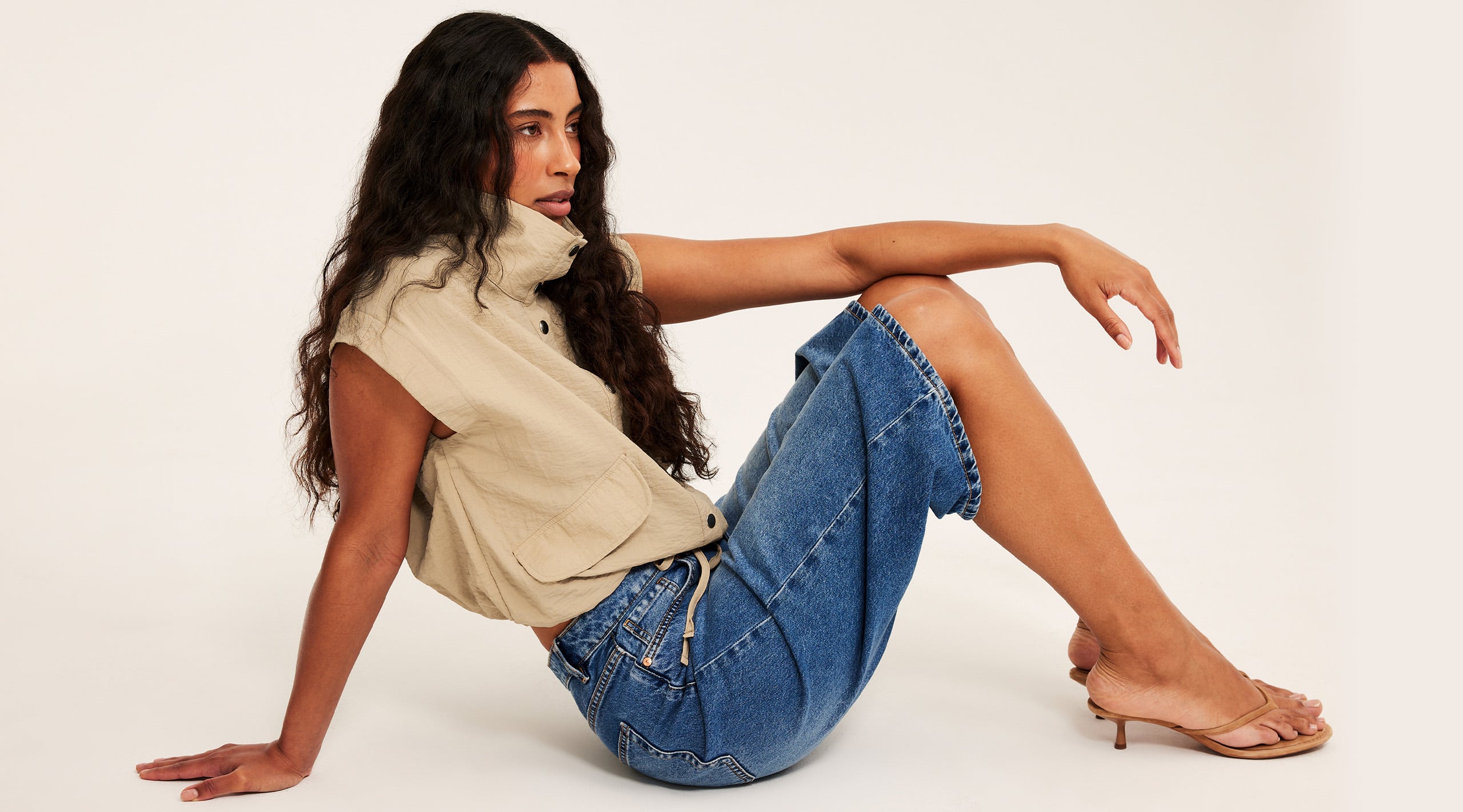 Kvinna i en beige topp med sportig look
