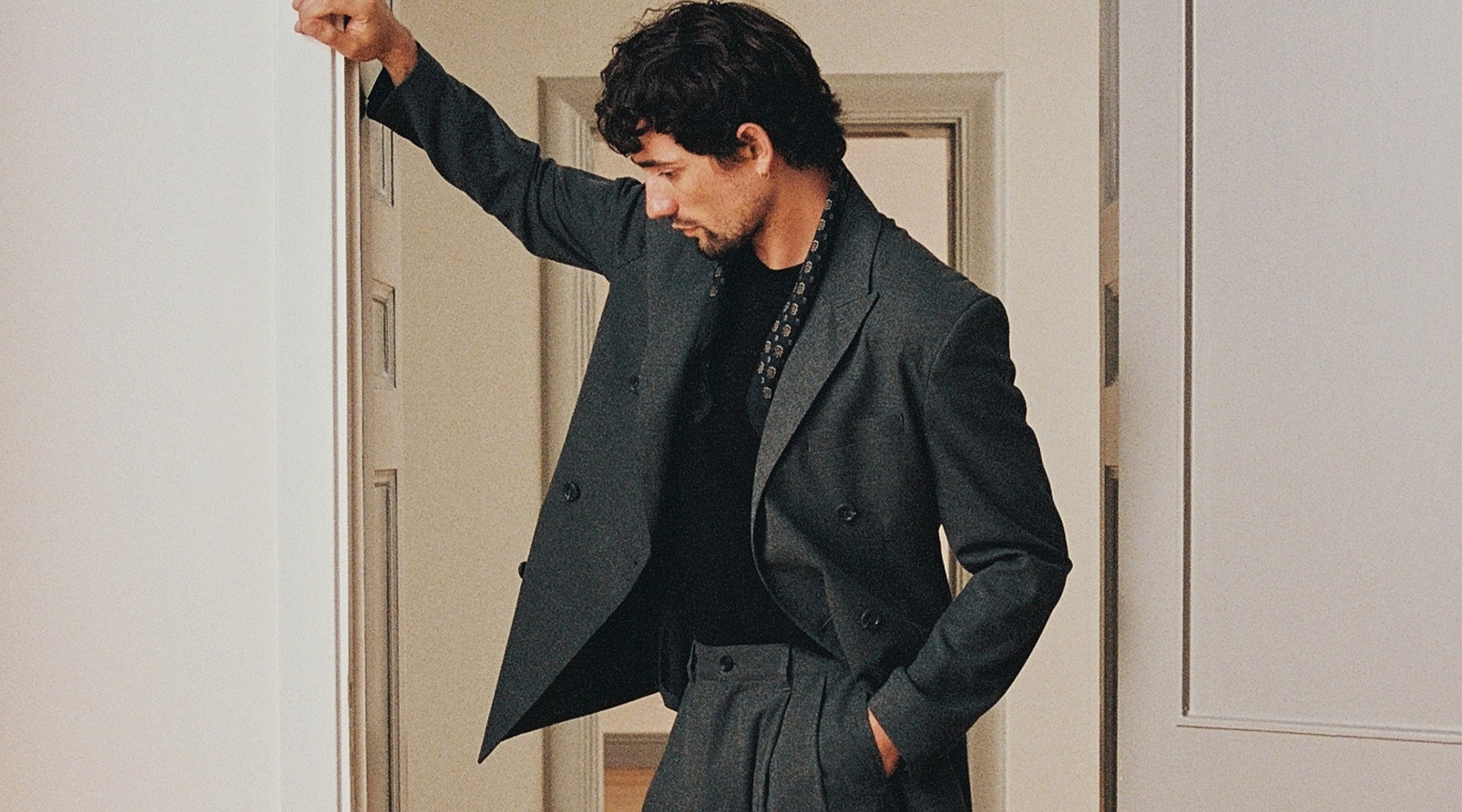 Man i kostym ståendes i en dörröppning.