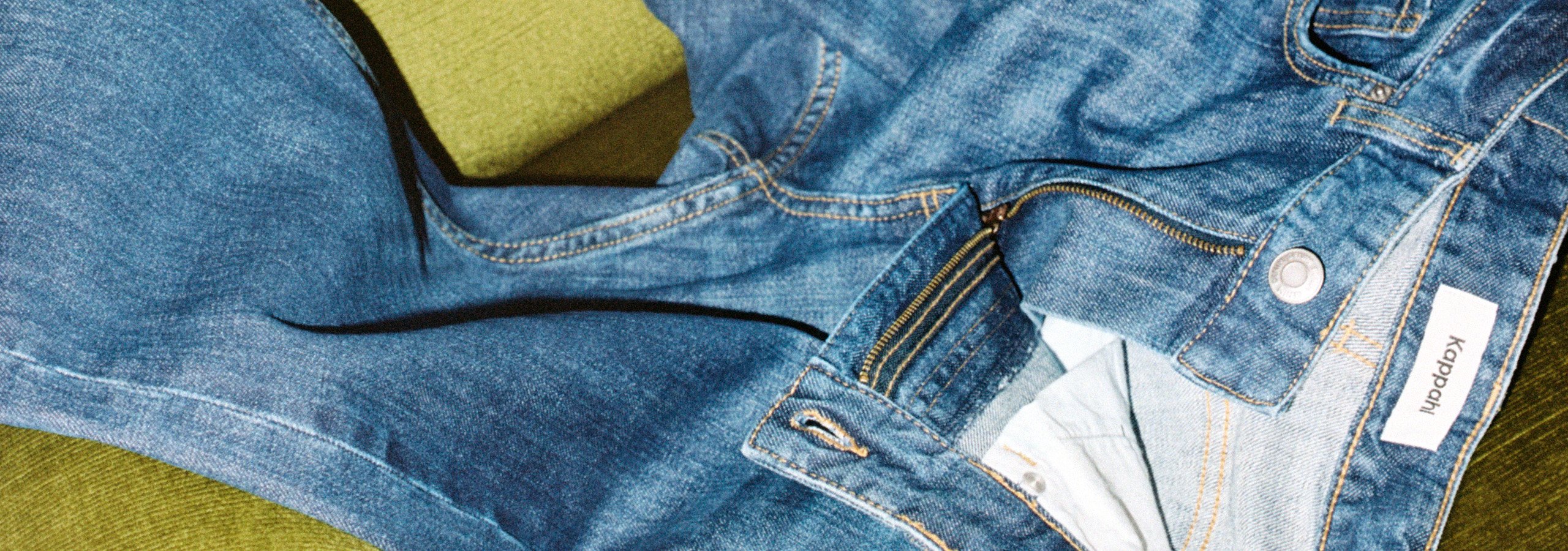 Blå jeans på en grønn sofa