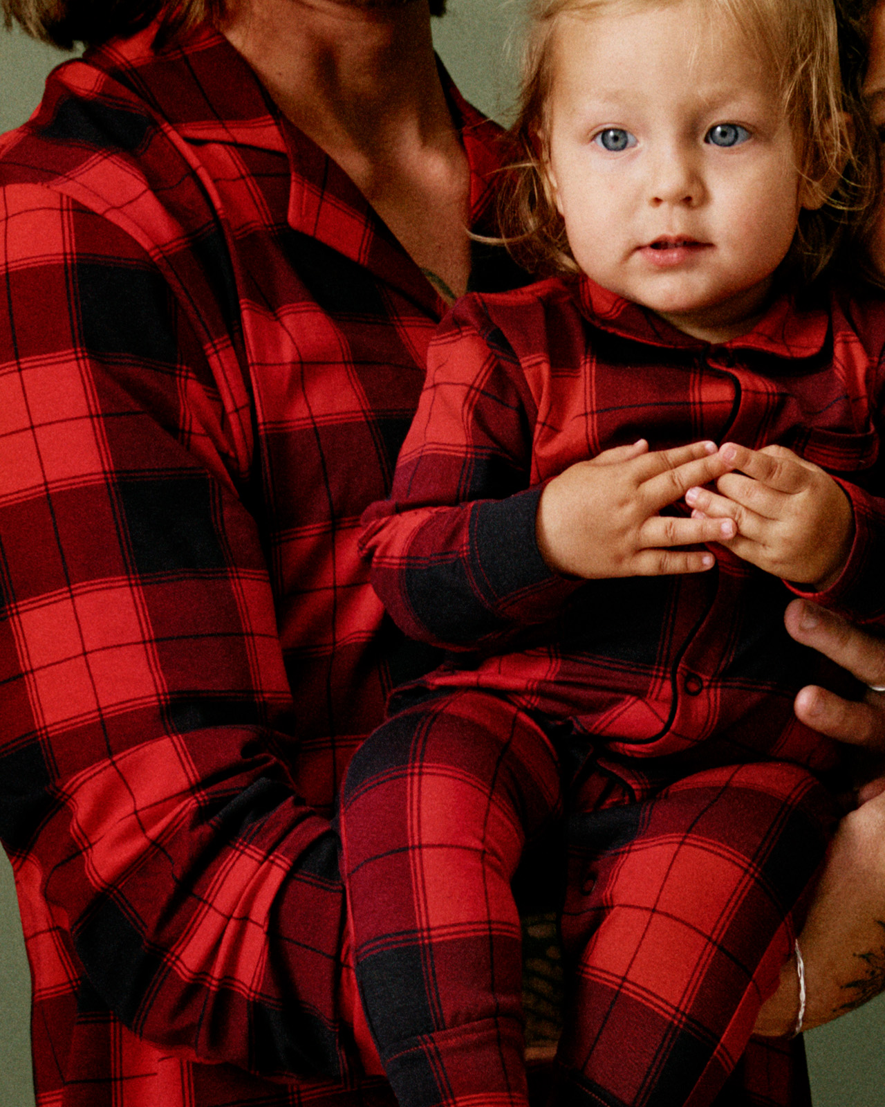 Baby och pappa i matchande julpyjamasar.