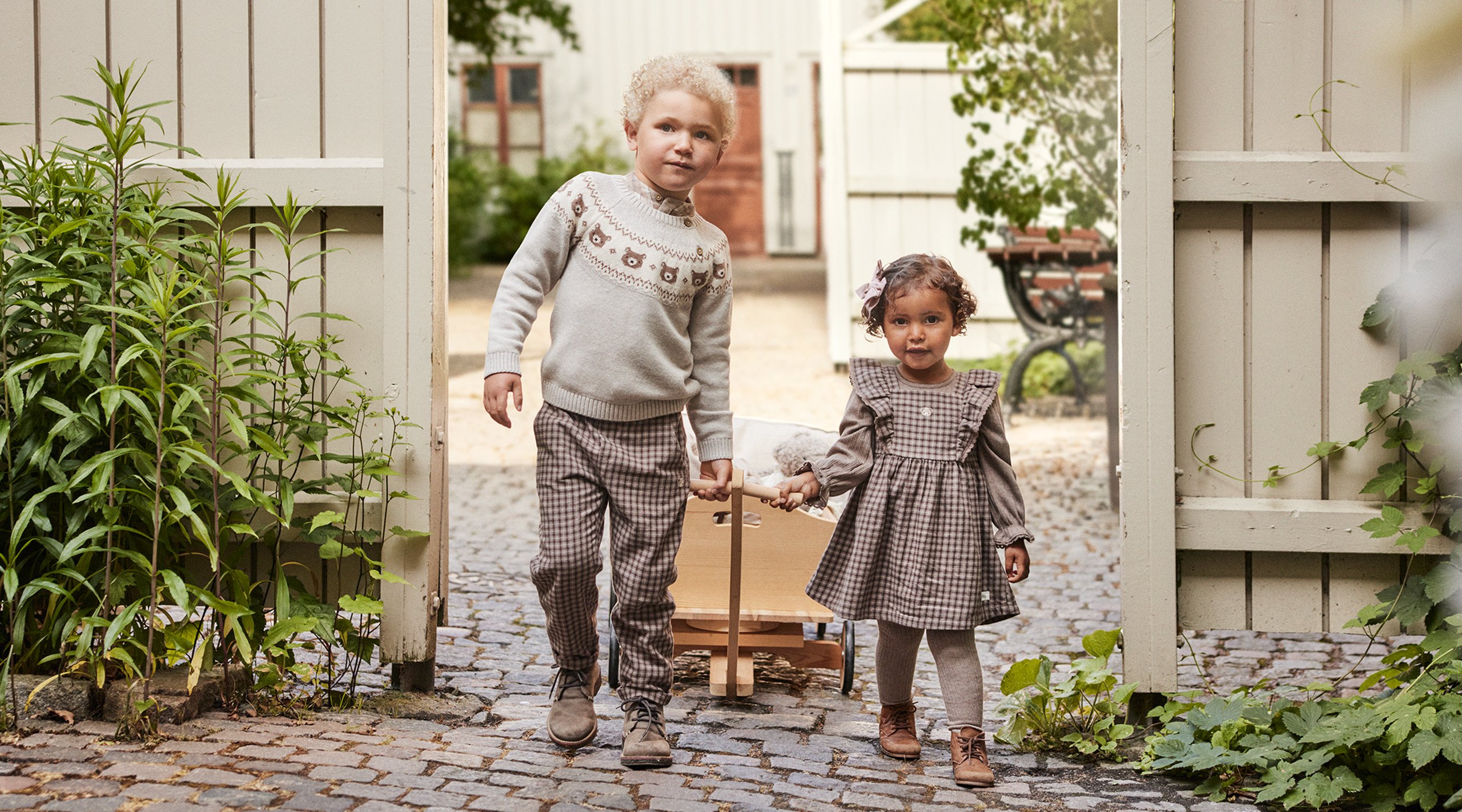 Mała dziewczynka i chłopiec w jesiennych strojach z nowej kolekcji Newbie.