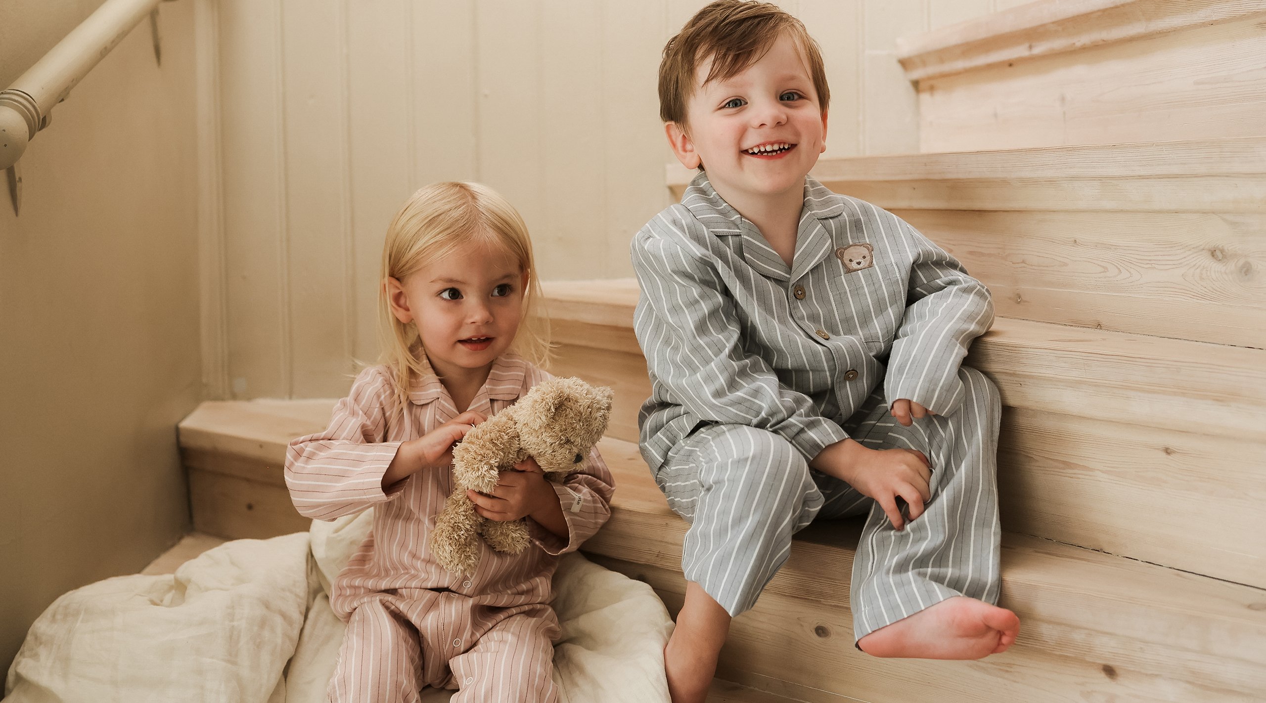 Barn sittandes i en trappa klädda i matchande pyjamasar från Newbie.