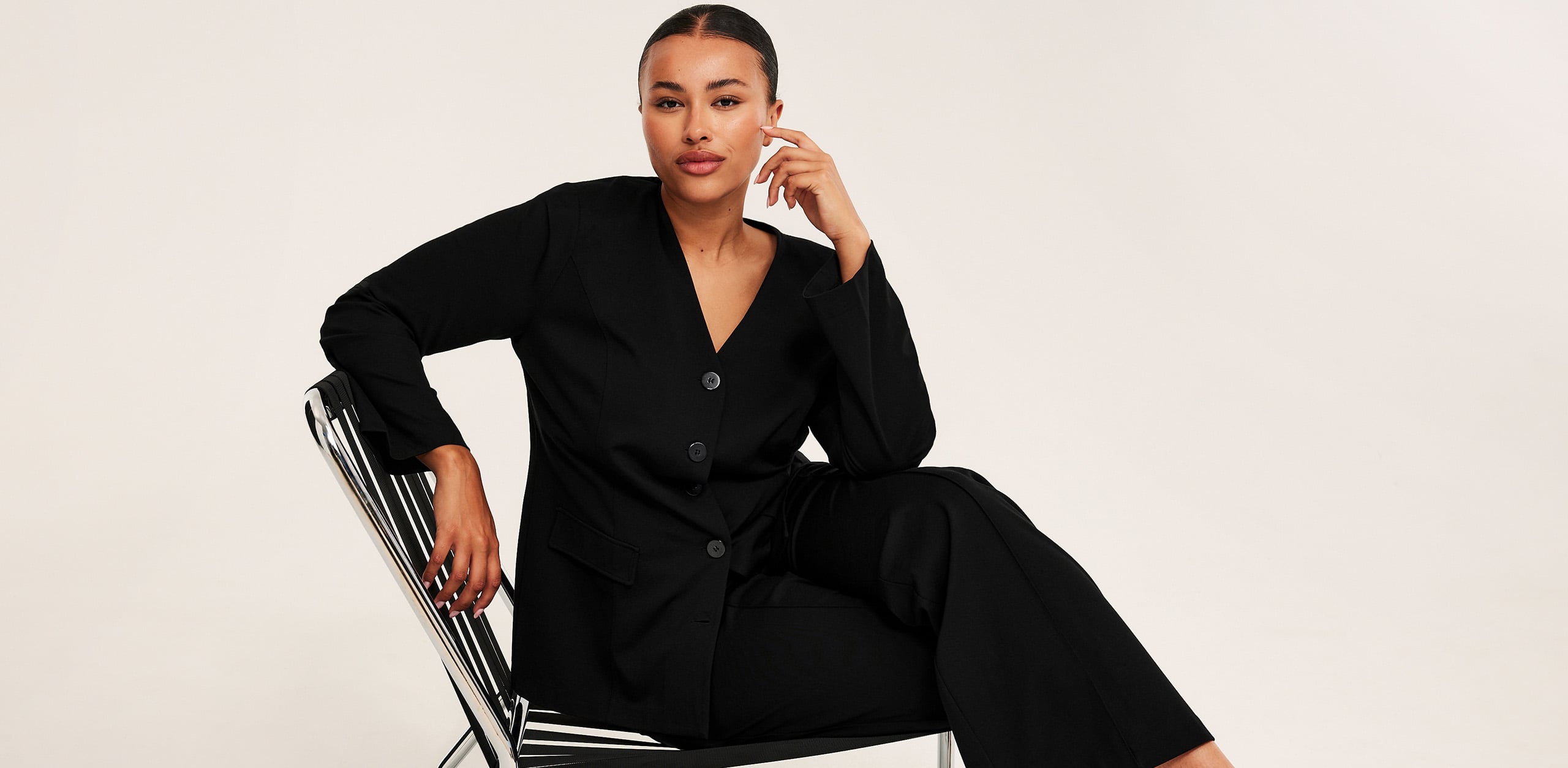 Plus size damkläder - Kvinna i svart kostym.