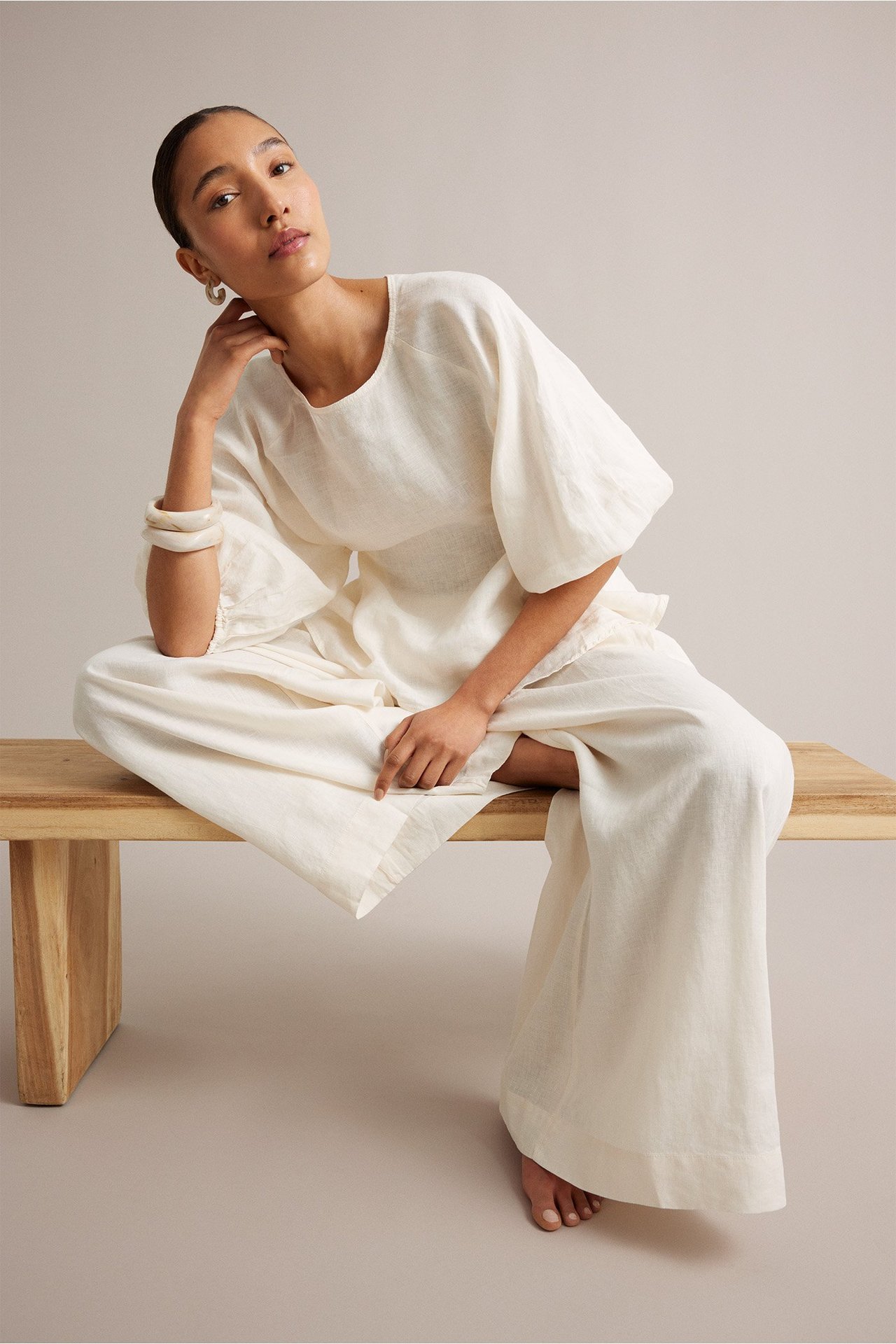 Kobieta w dzianinowym kardiganie i spodniach do relaksu.