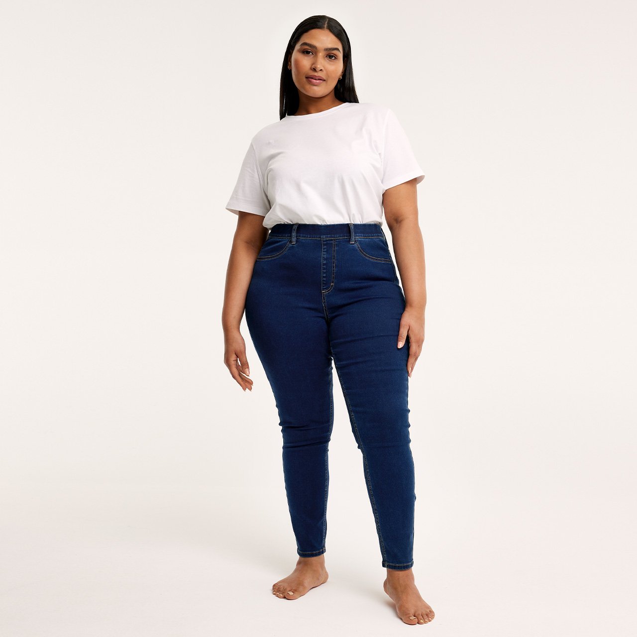 Kvinna med vit topp och slim jeans