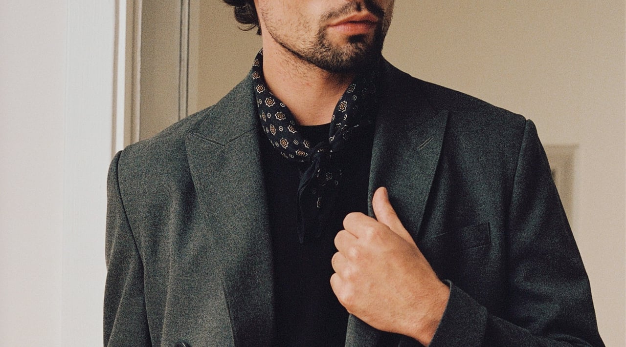 Herr med dubbelknäppt kavaj och scarf.