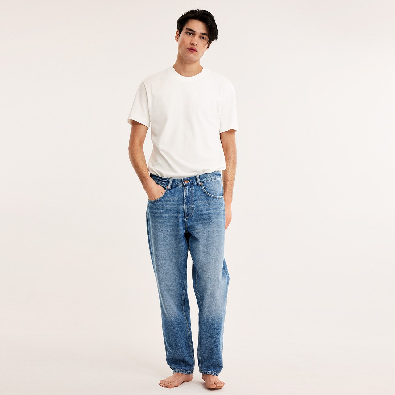 Mann med hvit t-skjorte og blå jeans