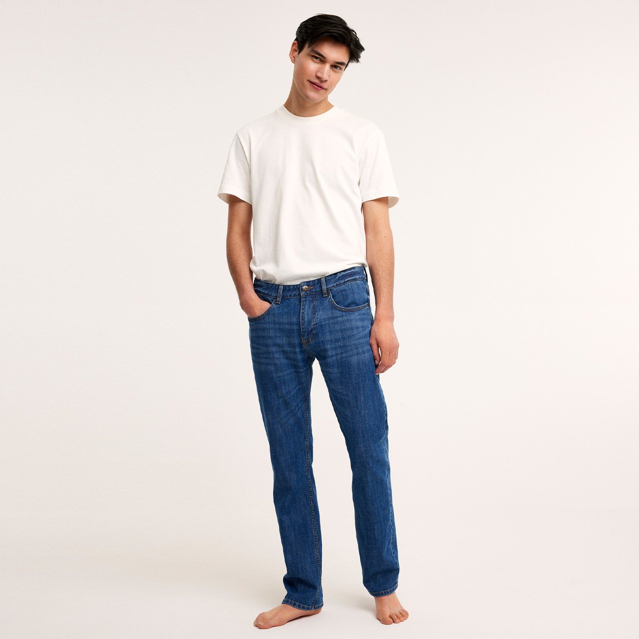 mann med hvit t-skjorte og blå jeans