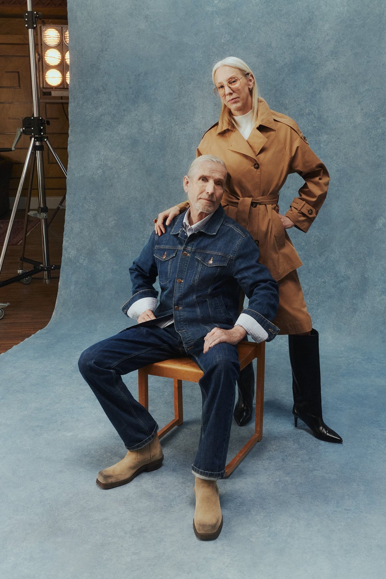 Miesten vaatteet: mies, jolla on yllään farkut ja niihin sopiva farkkutakki. Hänen vieressään seisoo nainen, jolla on yllään trenssitakki.