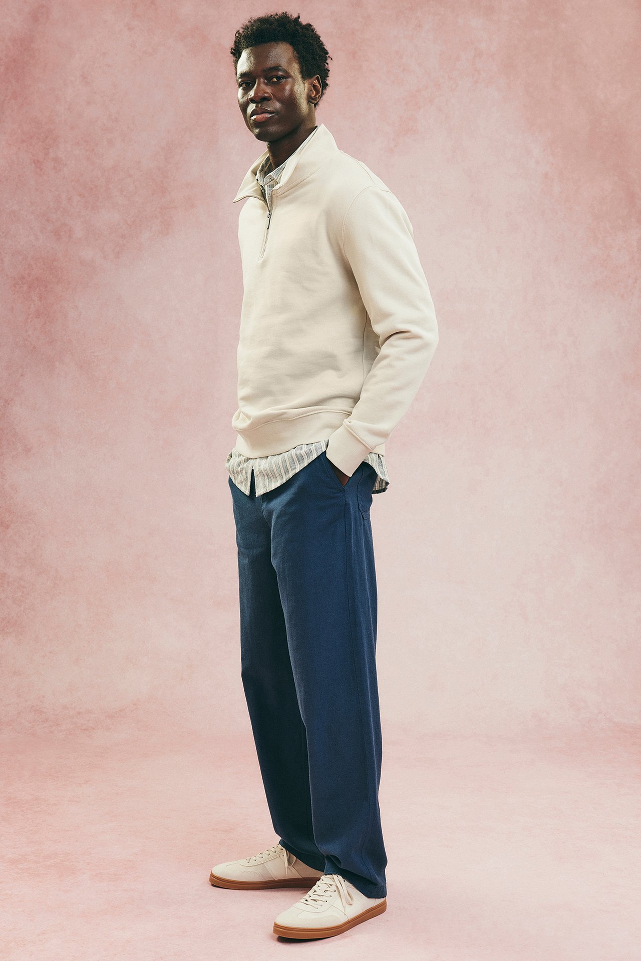 Mies, jolla on luonnonvalkoinen miesten pusero ja siniset linnehousut.