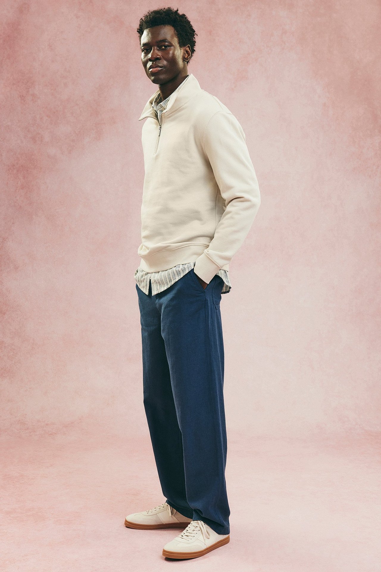 Mies, jolla on luonnonvalkoinen miesten pusero ja siniset linnehousut.