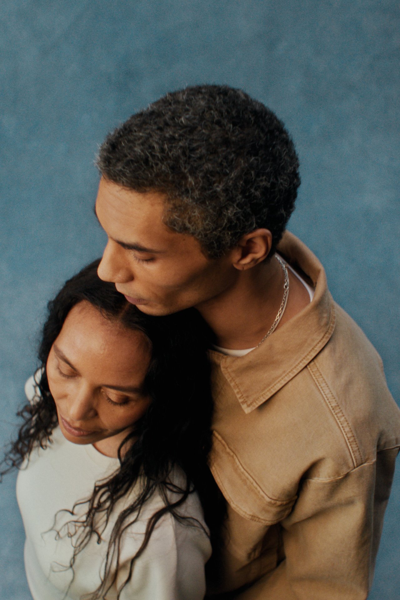 Miesten vaatteet: puuvillatwill-takkia pukeutunut mies seisoo naisen vieressä.