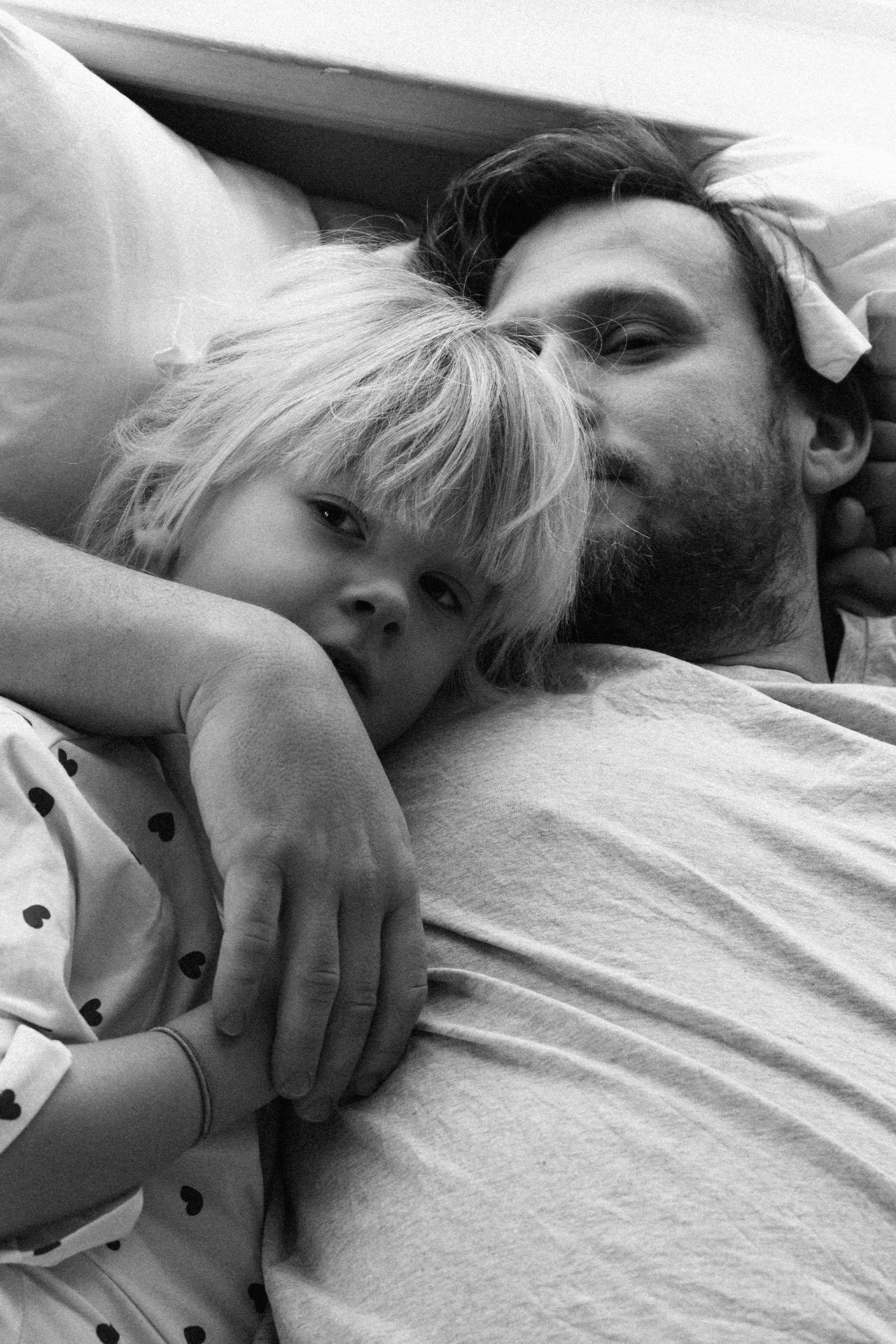 Mężczyzna i dziecko w jednakowych piżamach z serduszkami.