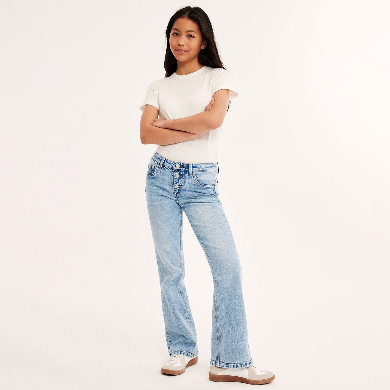 Tyttö kevyissä bootcut-farkuissa.