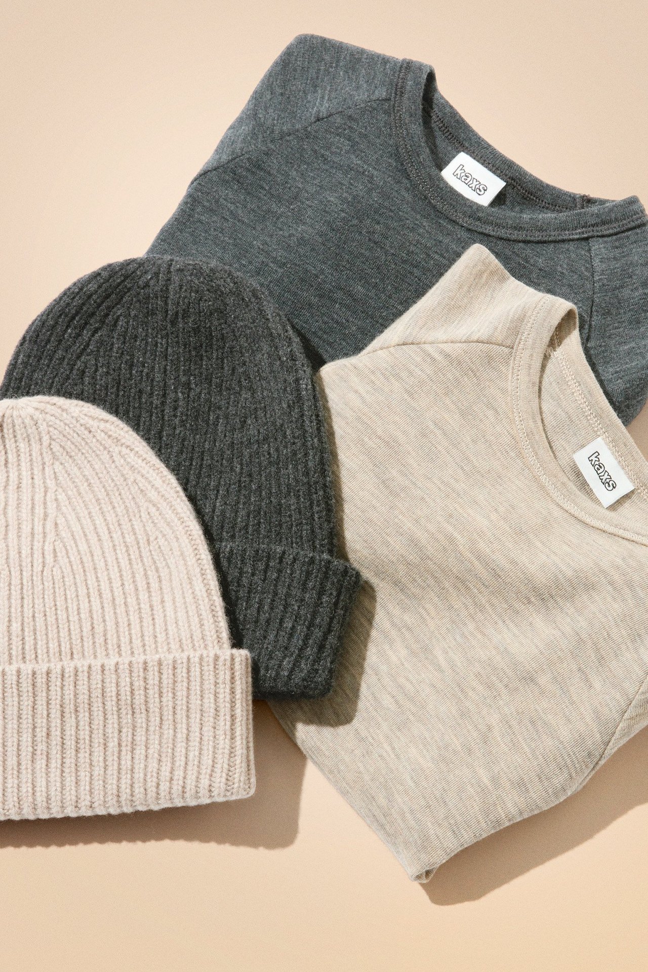 Ullgensere og -luer i beige og grått.