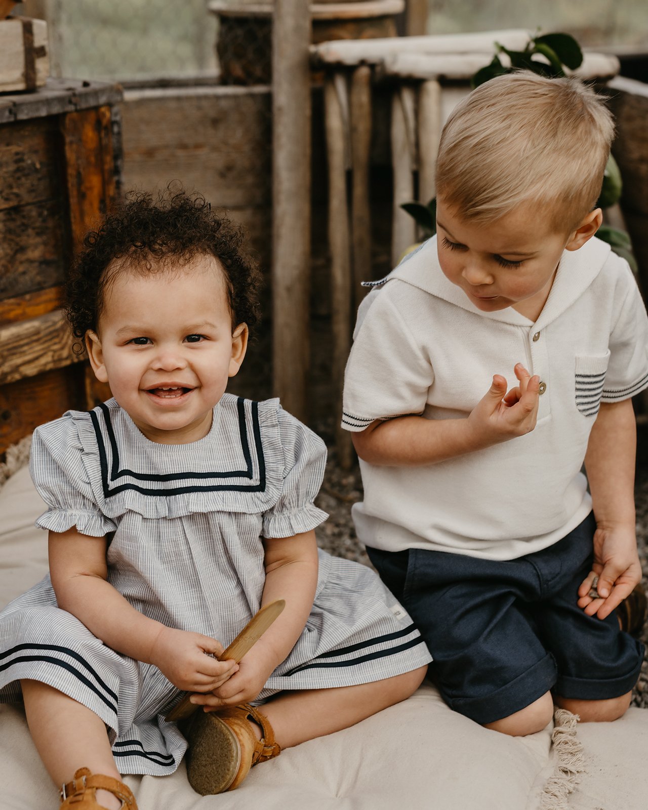 Vauva sinisellä mekolla ja lapsi aloittelijoiden vaatteilla