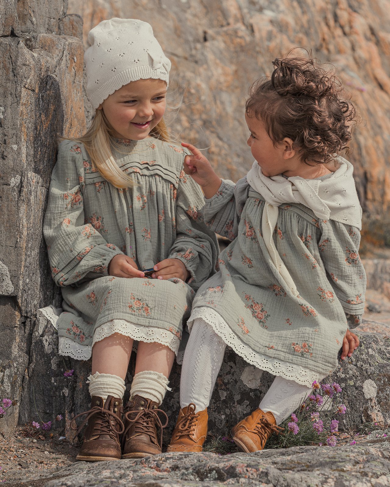 Jente og baby sitter sammen i Newbies nye kolleksjon.