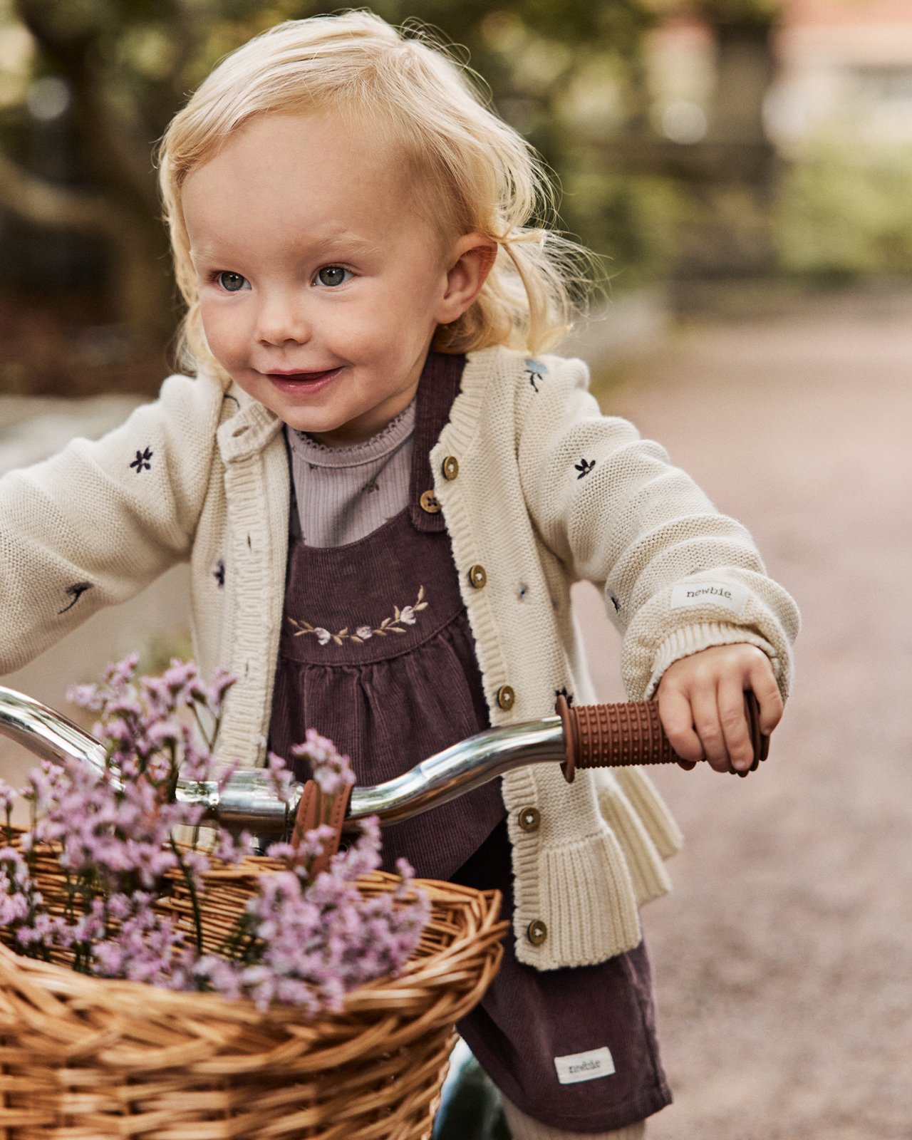 Dziewczyna na rowerze w ubraniach od Newbie.