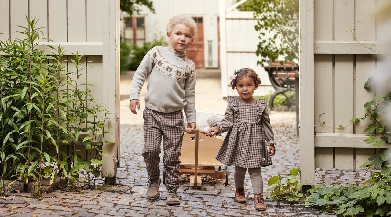 Mała dziewczynka i chłopiec w jesiennych strojach z nowej kolekcji Newbie.