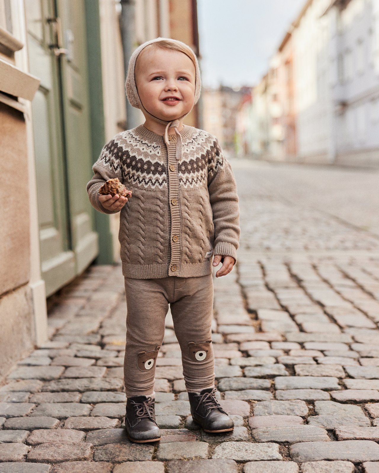 Kille klädd i mössa, brun stickad tröja och leggings från Newbie.
