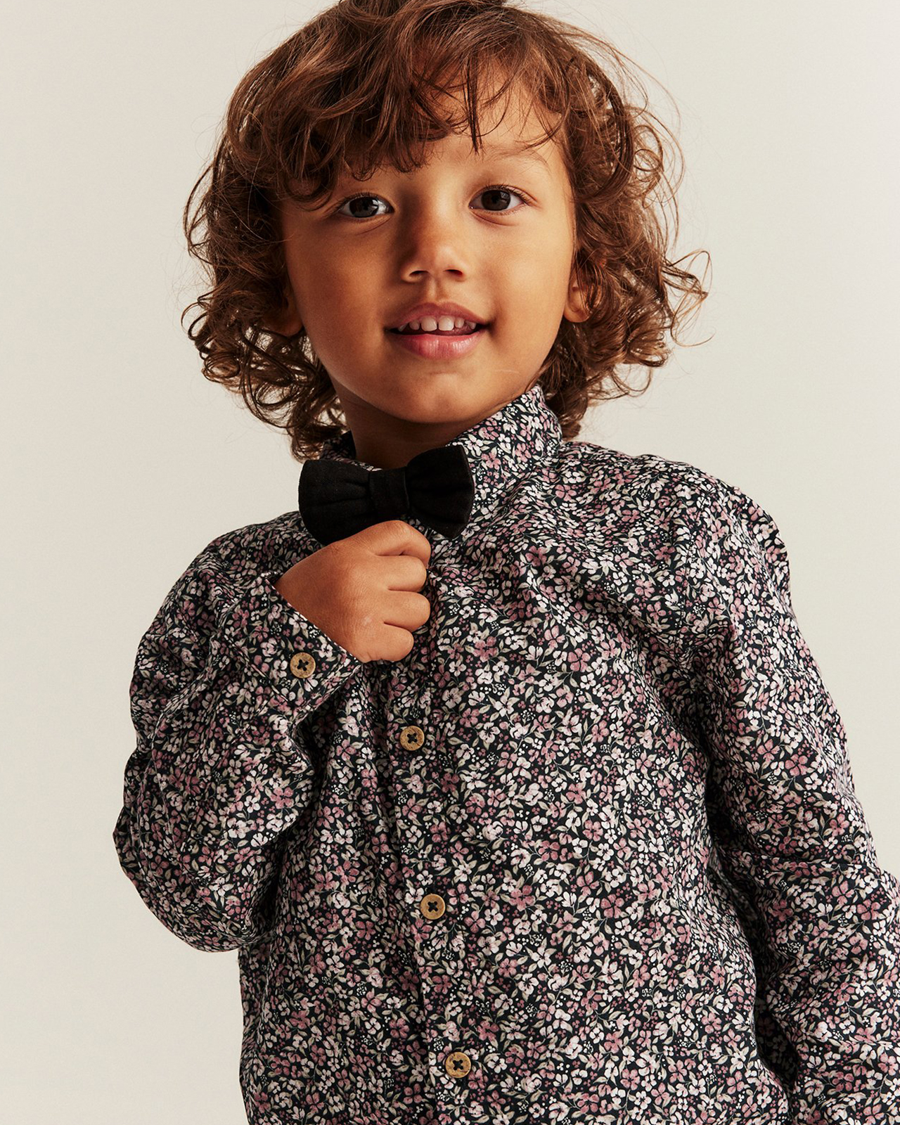 Brązowowłosy facet ubrany w fioletową koszulę w kwiaty z Newbie.