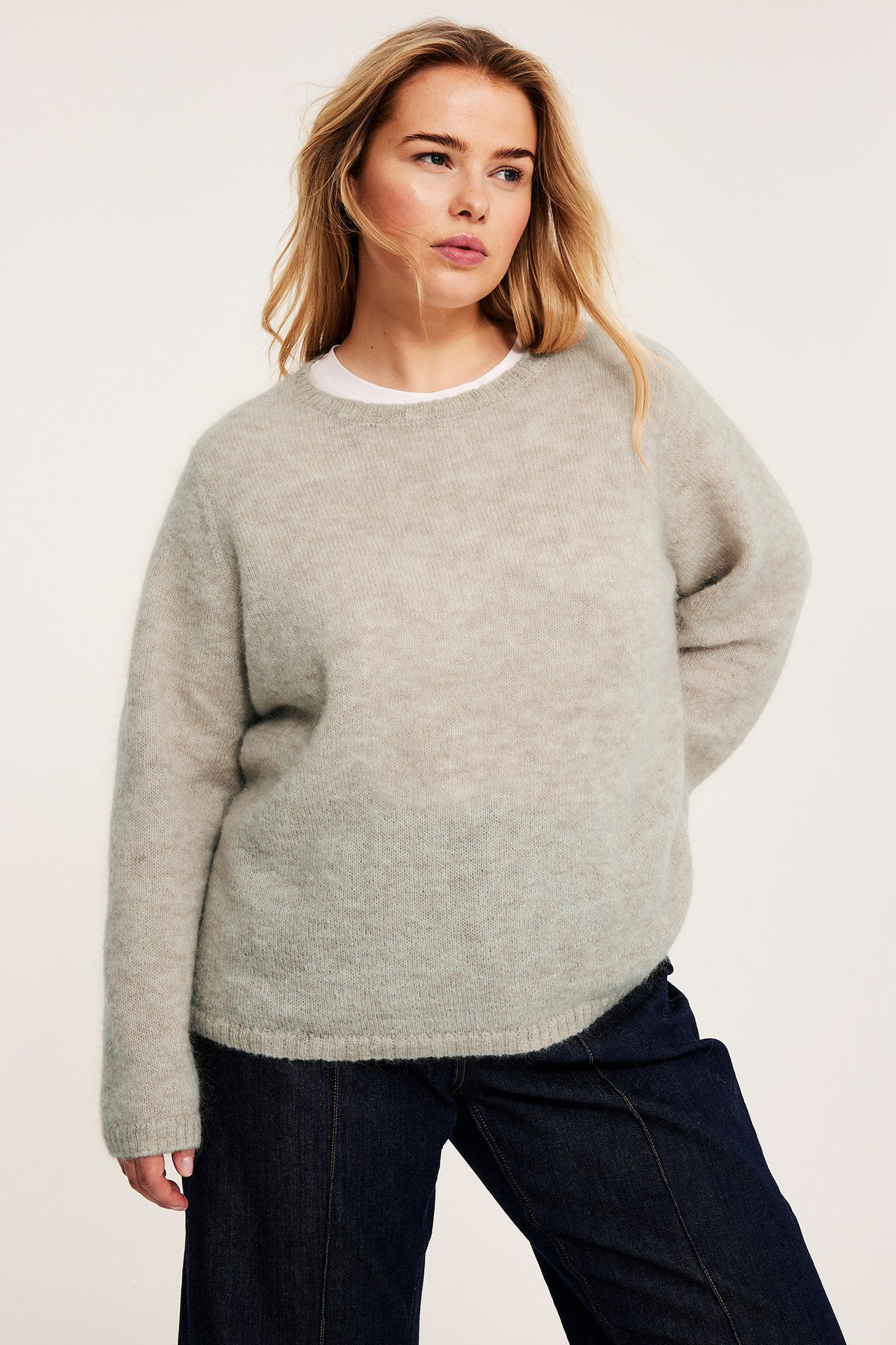 kvinna i stickad tröja och jeans