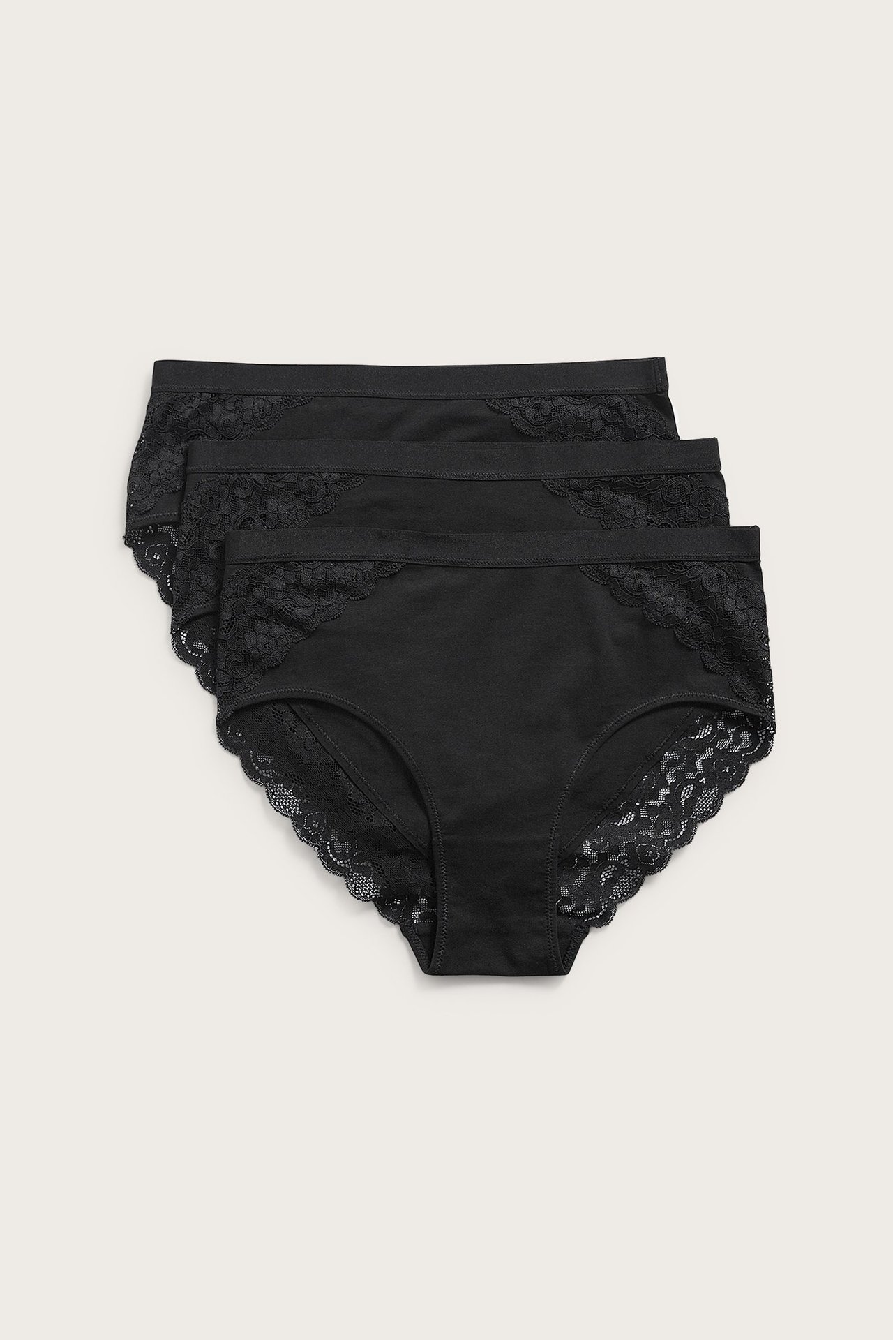 Forfra: tre svarte dame-bomullstruser med blondedetaljer på sidene og benåpningene.