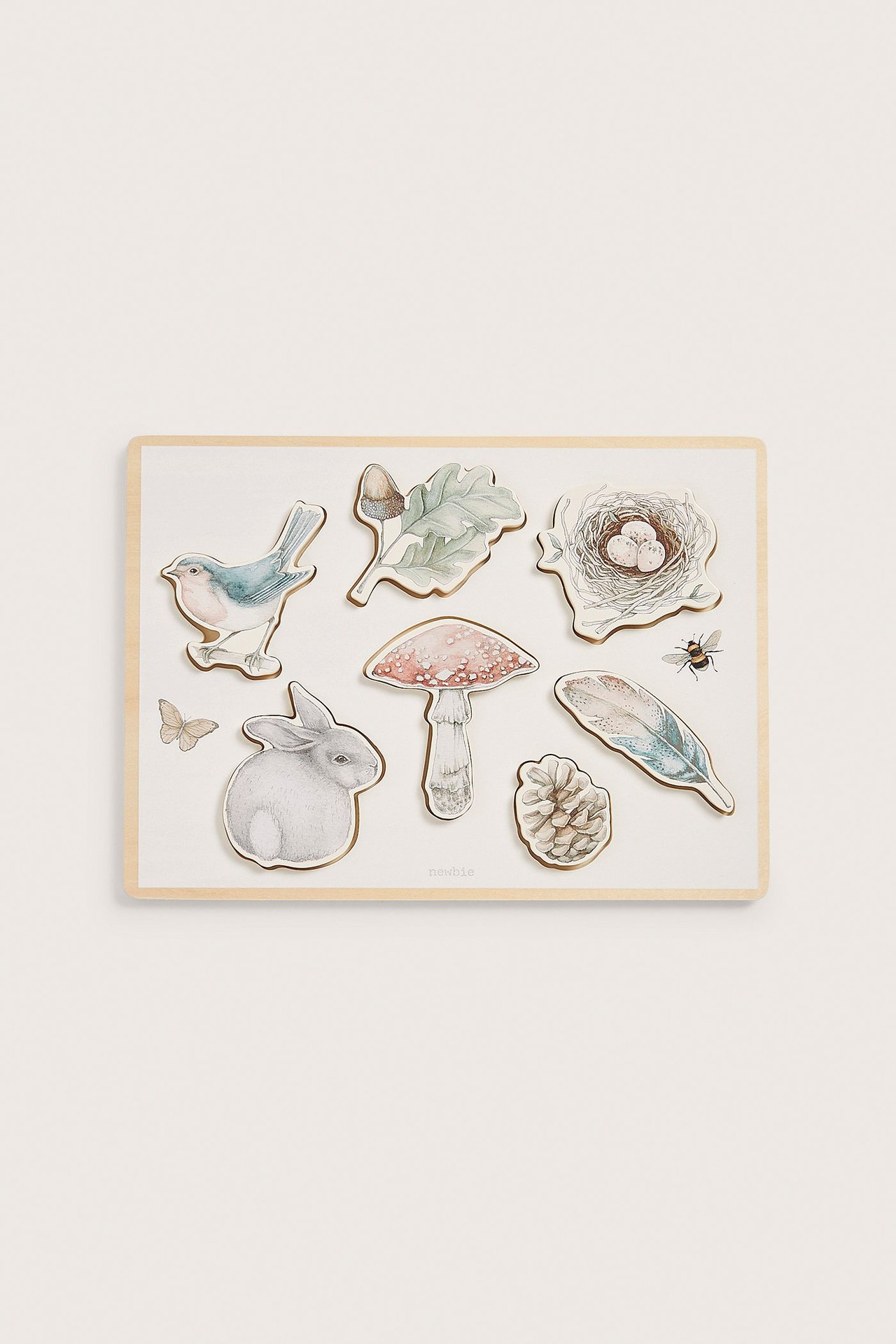 Widok z przodu na kremową drewnianą układankę z siedmioma leśnymi zwierzętami i motywami natury.