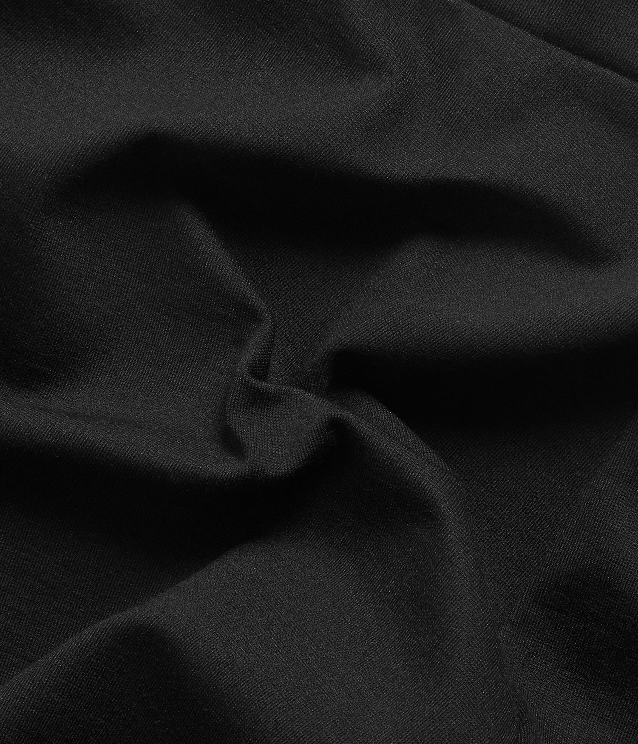 Zbliżenie czarnego materiału ponte roma z widocznymi fałdami i subtelną dzianinową teksturą.