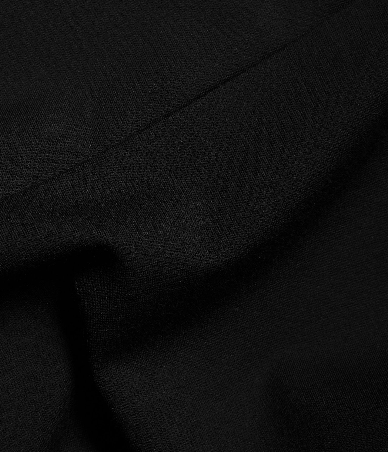 Zbliżenie na czarny, jednolity materiał legginsów loungewear o miękkiej fakturze.