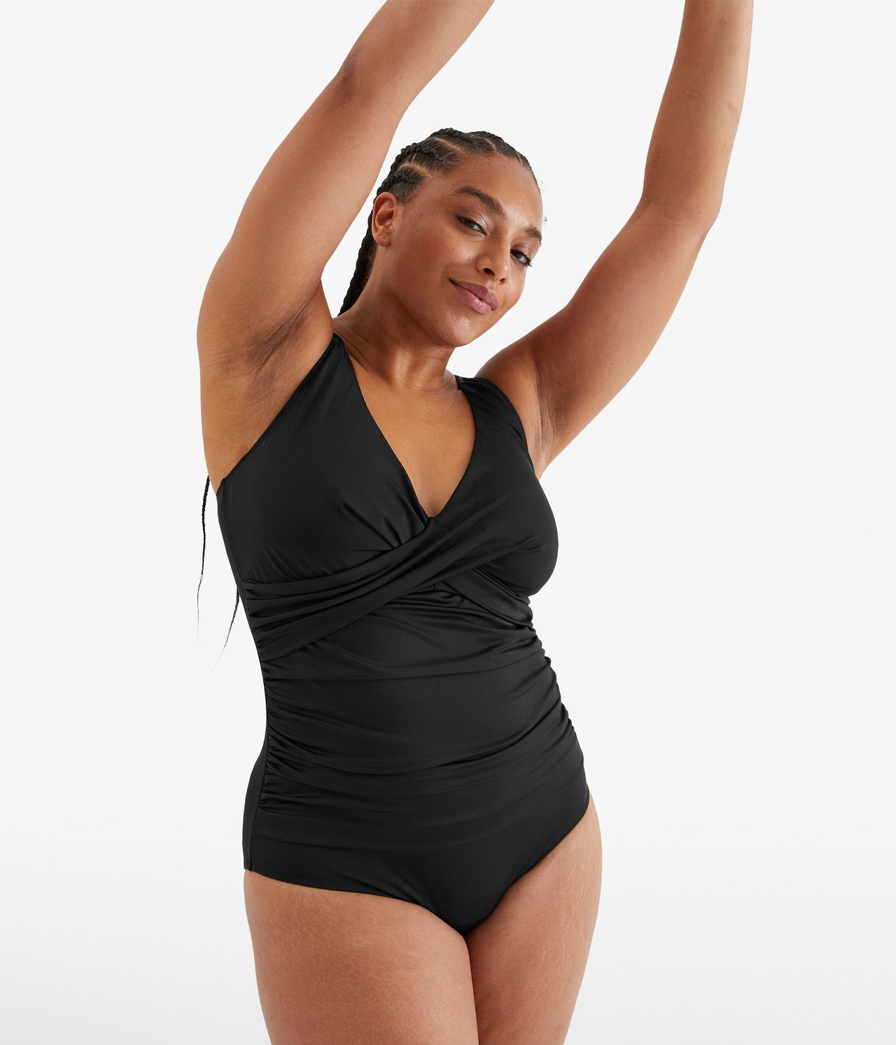 Widok z przodu: kobieta w czarnym kostiumie kąpielowym z dekoltem V, kopertowym przodem i drapowanymi bokami.