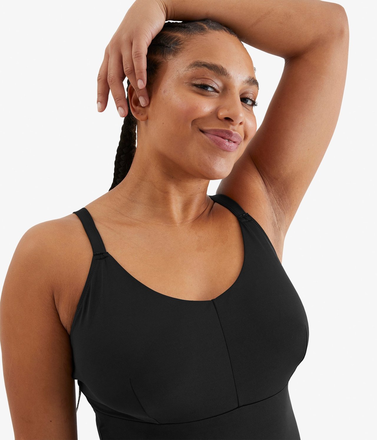 Zbliżenie z przodu kobiety w czarnym, nieusztywnianym kostiumie kąpielowym.