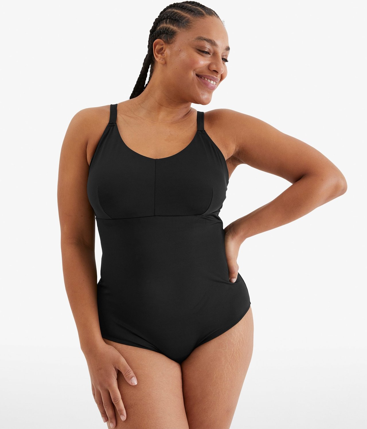 Widok z przodu: Kobieta w jednolitym czarnym, nieusztywnianym kostiumie kąpielowym z regulowanymi ramiączkami.