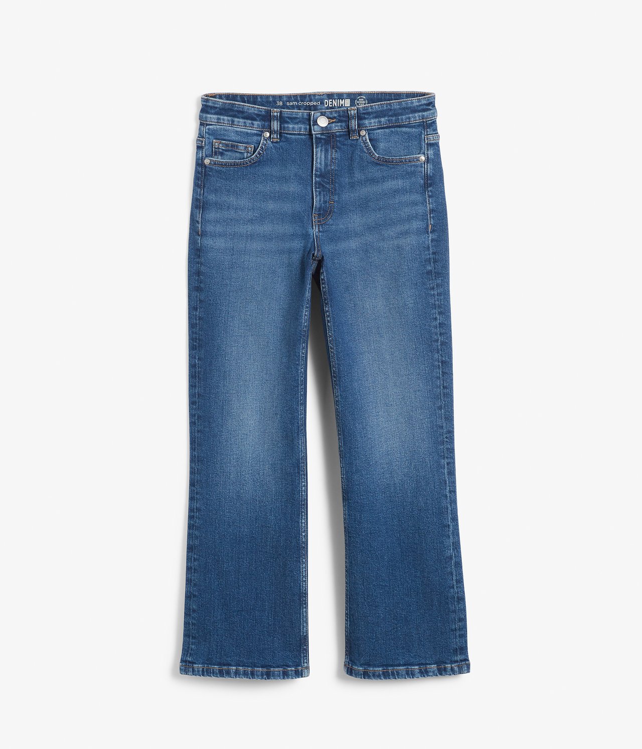 Framifrån: blå denim cropped flare jeans med normal midja och femficksmodell.
