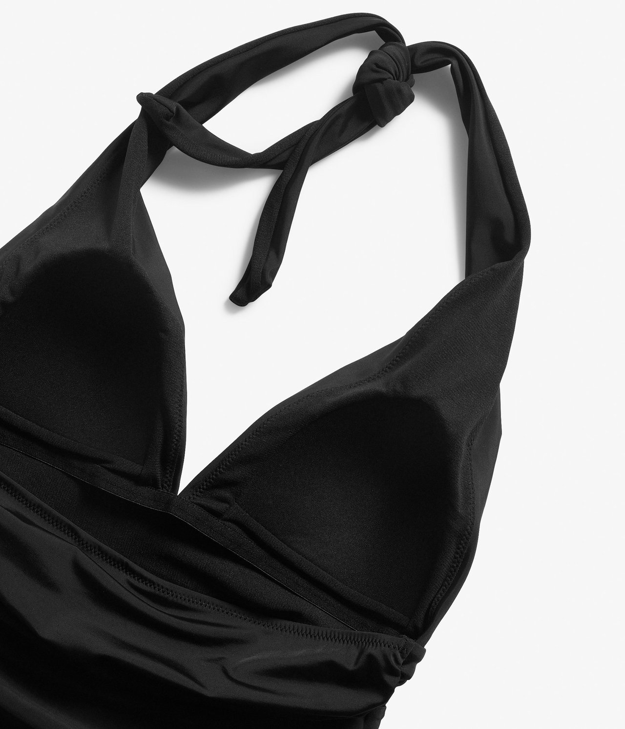 Zbliżenie czarnego jednoczęściowego kostiumu kąpielowego z wiązaniem na szyi i marszczeniami.