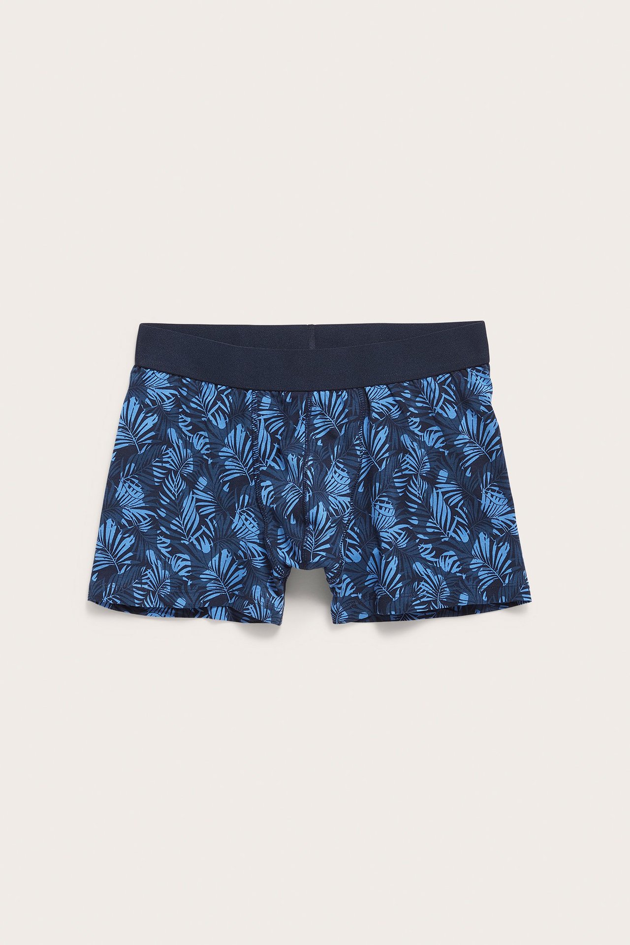 Frontvy av blå, mønstrede jersey-boxershorts for menn med marineblå strikk i livet.
