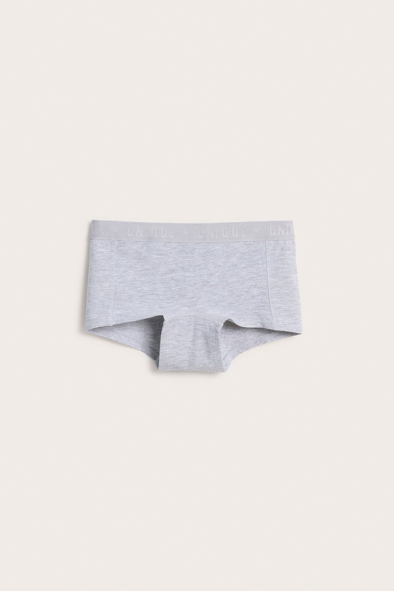 Edestä, vaaleanharmaat lasten luomupuuvillasekoitebokserit, joissa joustava vyötärönauha 'UNIQUE'-tekstillä.