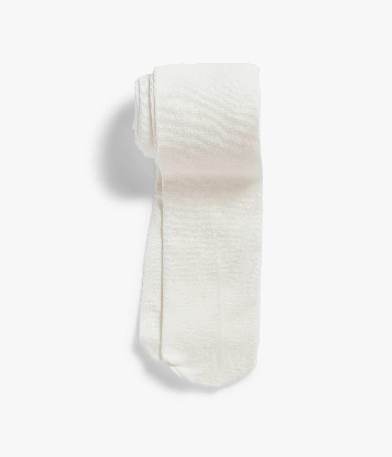 Uppifrån sett, enfärgade stickade offwhite strumpbyxor, prydligt vikta.