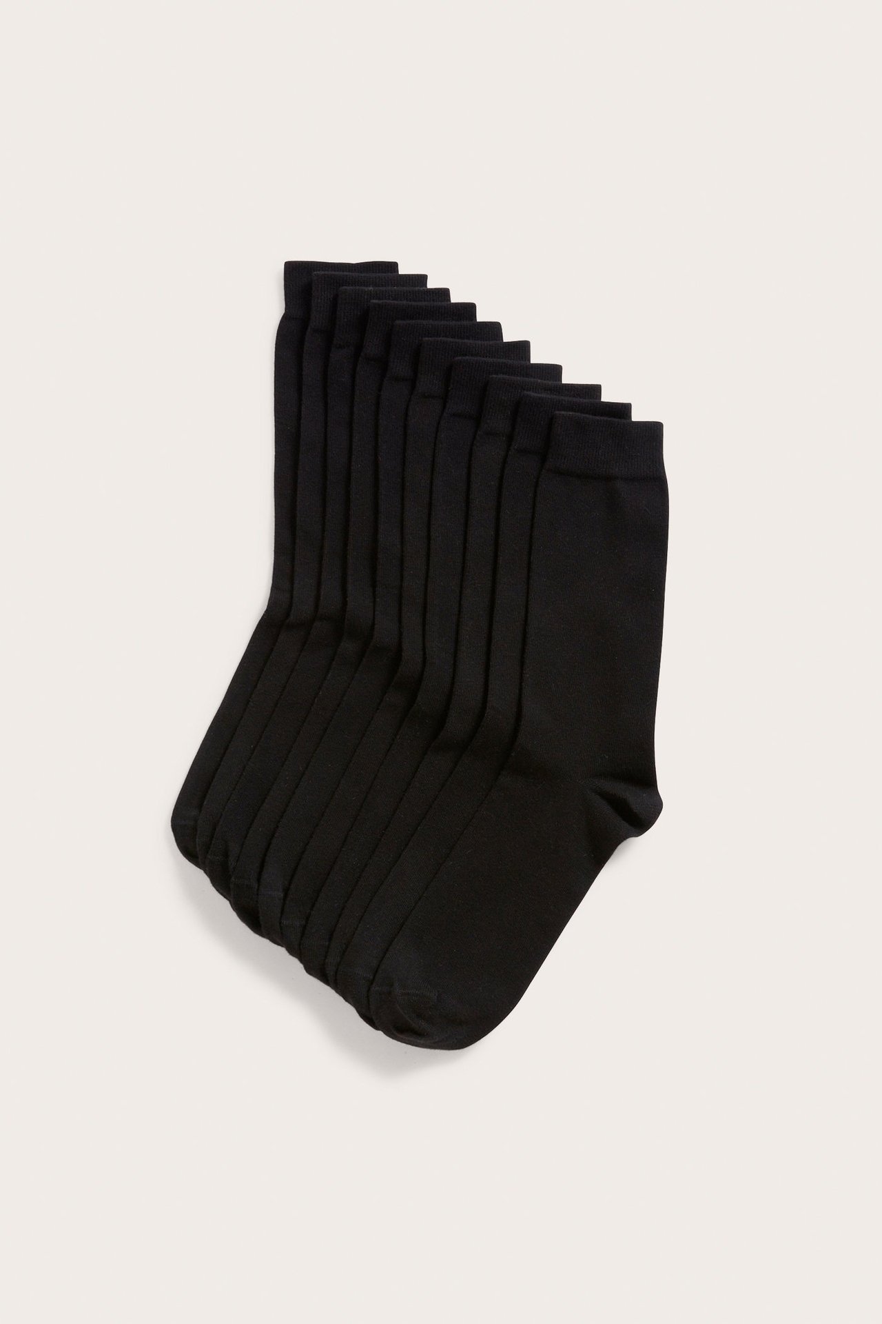 Uppifrån vy av ett 10-pack enfärgade svarta strumpor i bomullsblandning, prydligt staplade.
