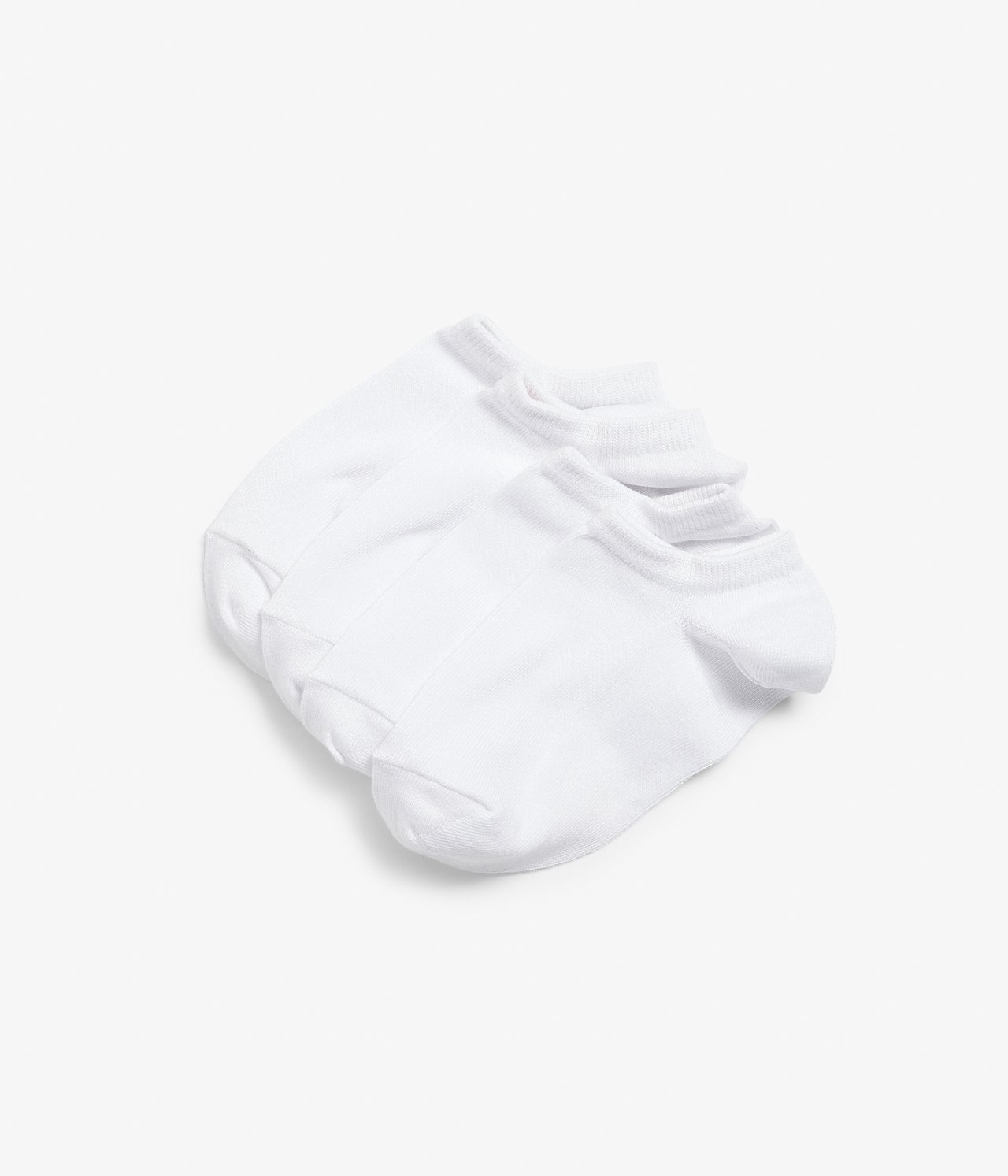 Uppifrån sett, fyra par enfärgade vita sneakersstrumpor i bomullsblandning, prydligt staplade.