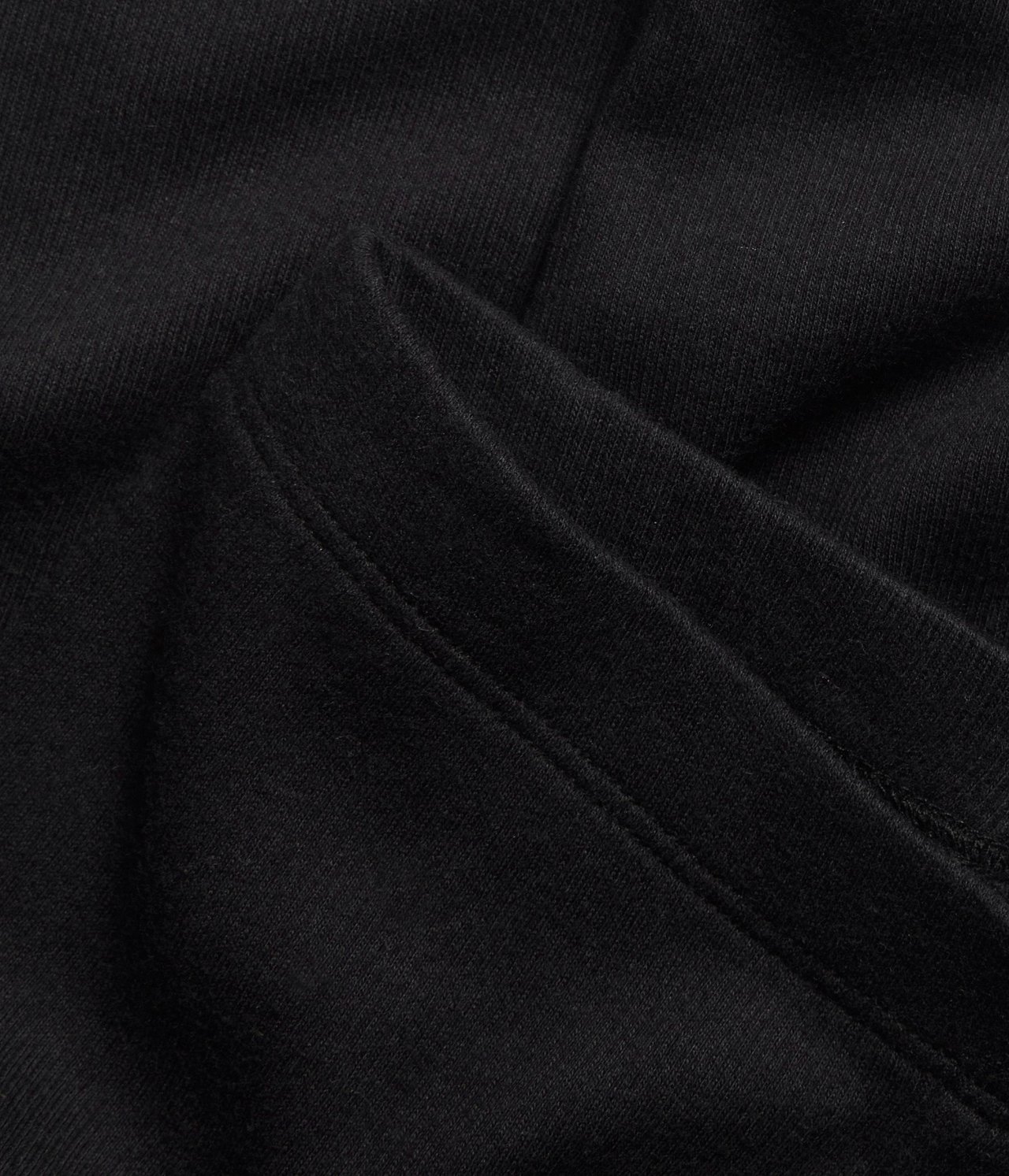 Zbliżenie czarnych, prążkowanych legginsów z mieszanki bawełny z widocznymi szwami.