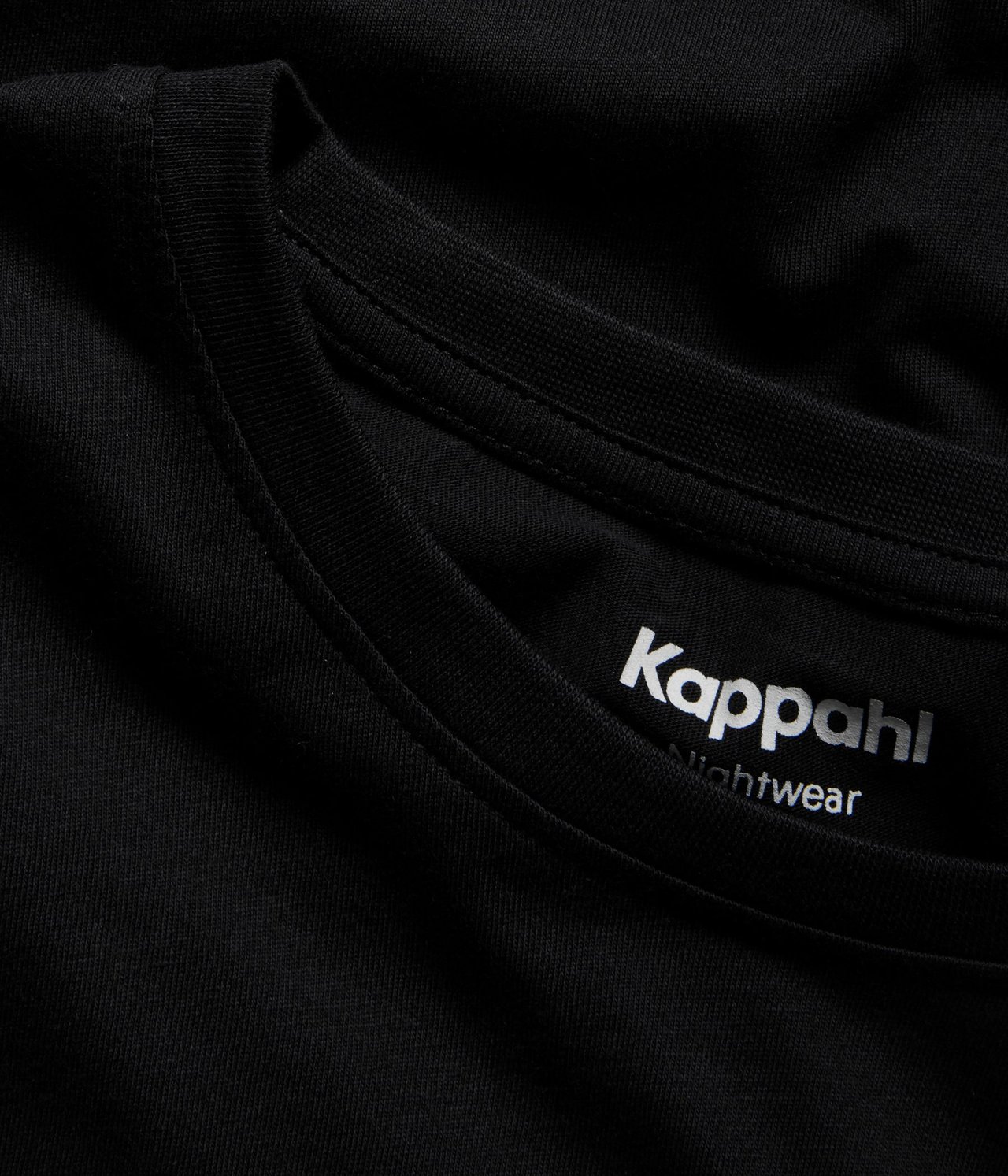 Zbliżenie czarnej bawełnianej piżamy męskiej z okrągłym dekoltem.