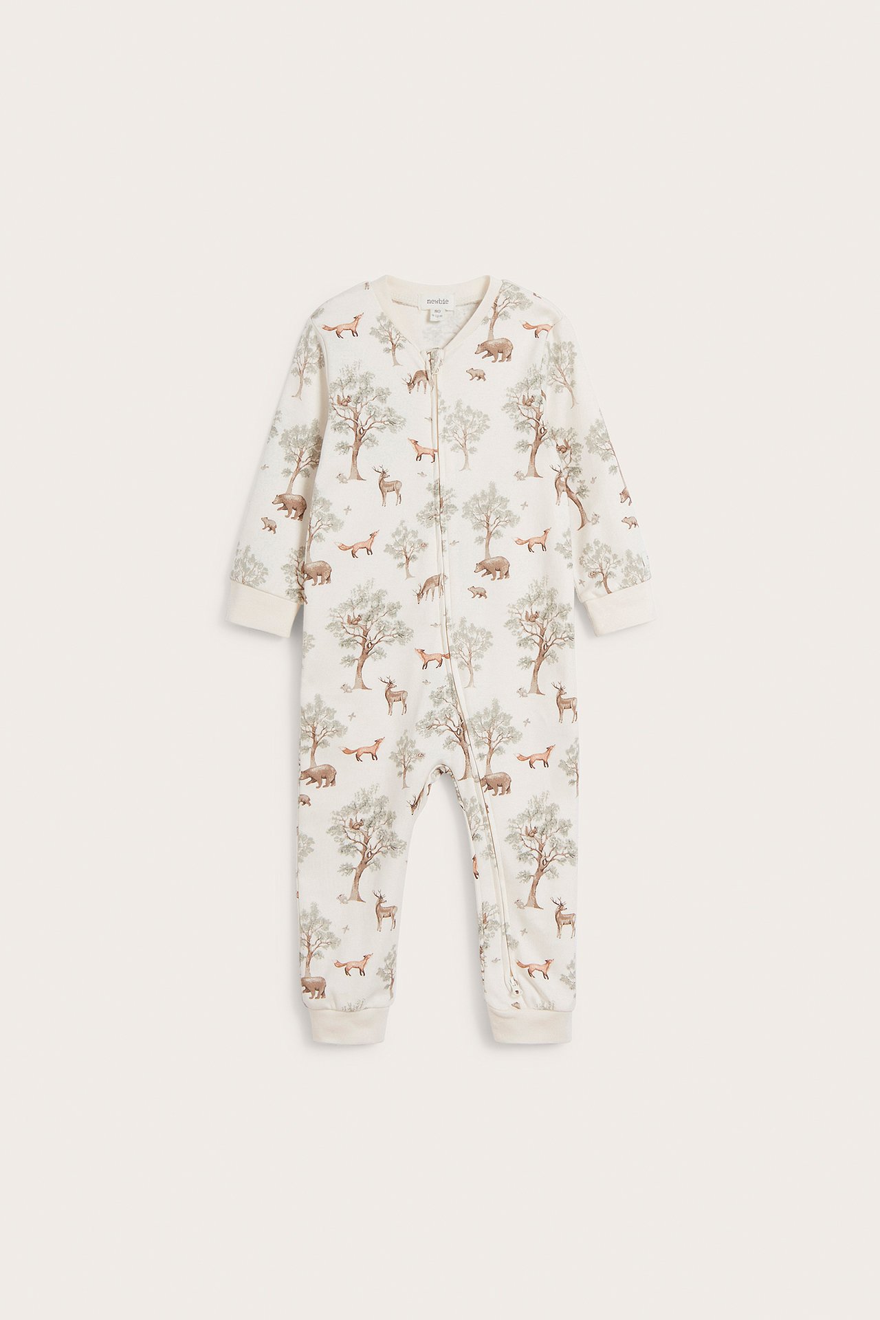 Edestä kuvattu luonnonvalkoinen vauvan pyjama metsäkuviolla ja kaksisuuntaisella vetoketjulla edessä.