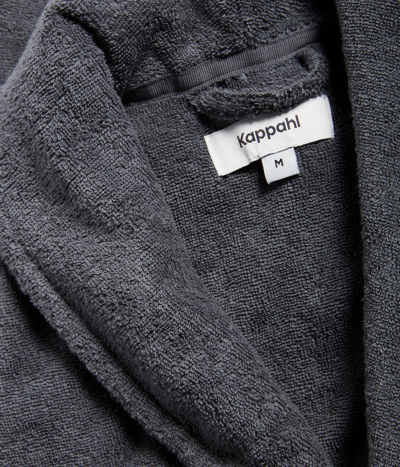 Zbliżenie na ciemnoszary, jednolity, gruby szlafrok z bawełnianej froty.